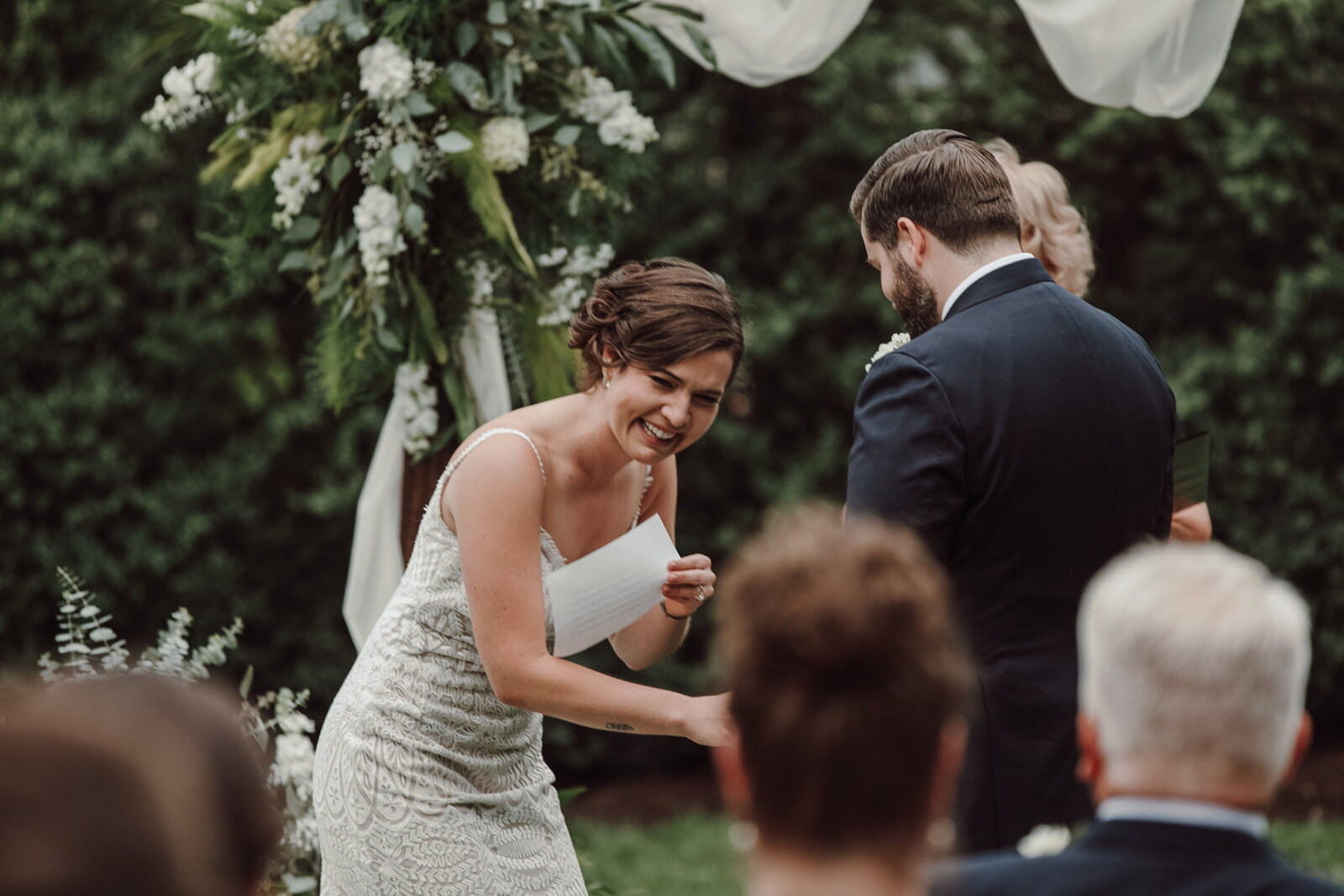 A bride laughs during her backyard wedding ceremony