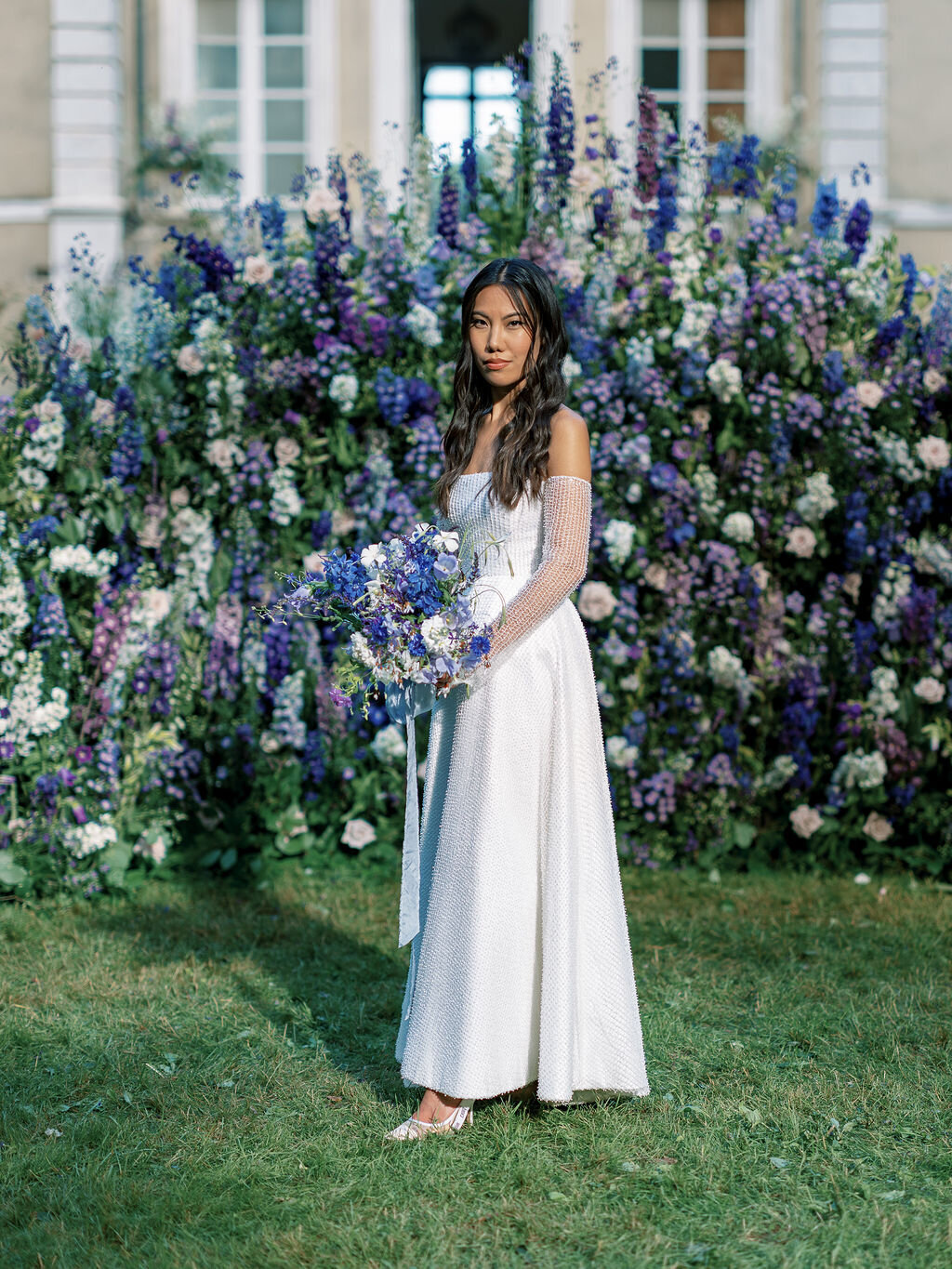 blu and lilac backdrop  with a bride wearing a dior dress