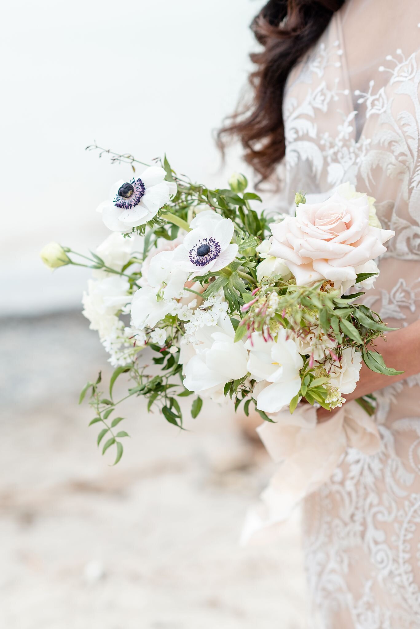 Bride-walking-along-the-beach-with-her-stunning-wedding-bouquet