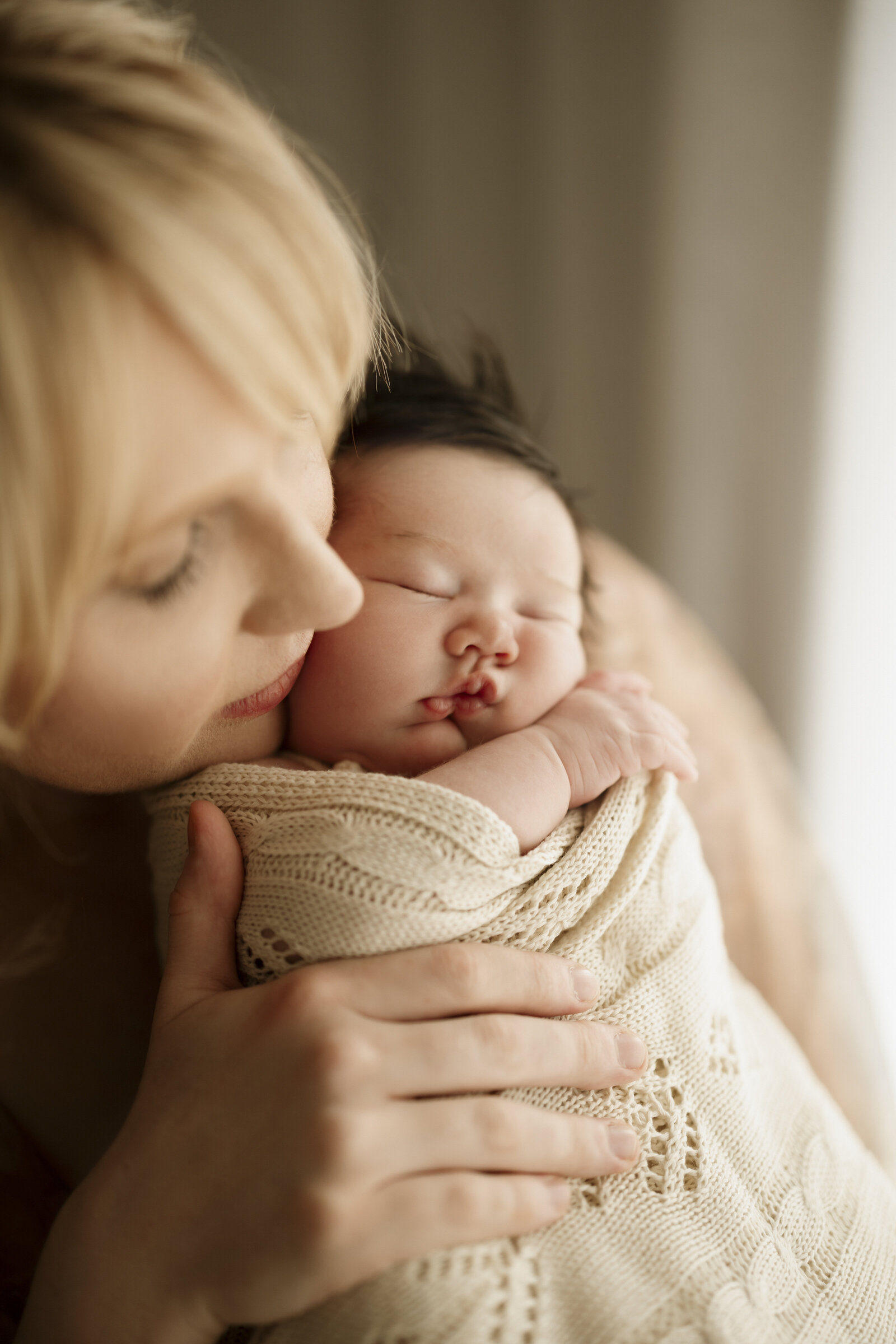A peaceful and elegant Perth newborn studio photography session, highlighting the bond between baby and parents.