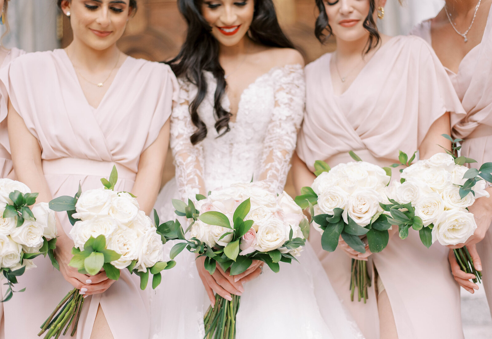 bride with bridesmaids wearing pink dresses holding bouquets