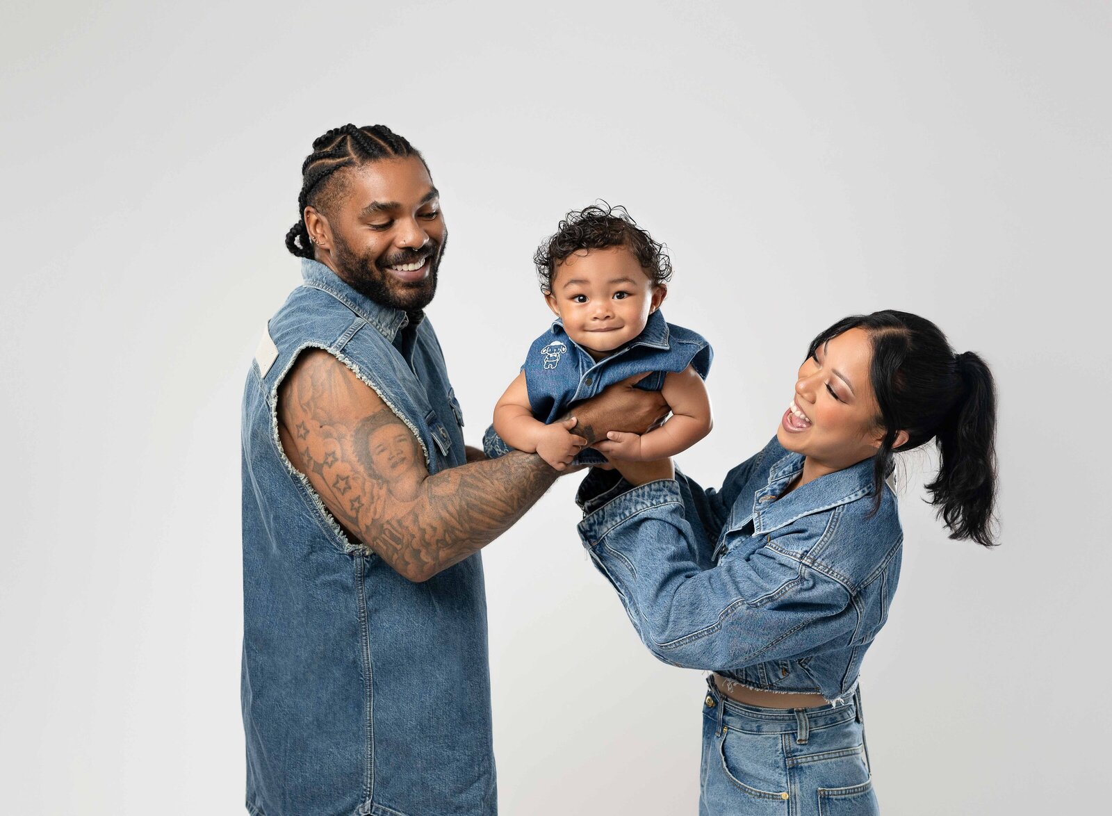 Mom and Dad holding baby in the middle and swinging him on his belly.