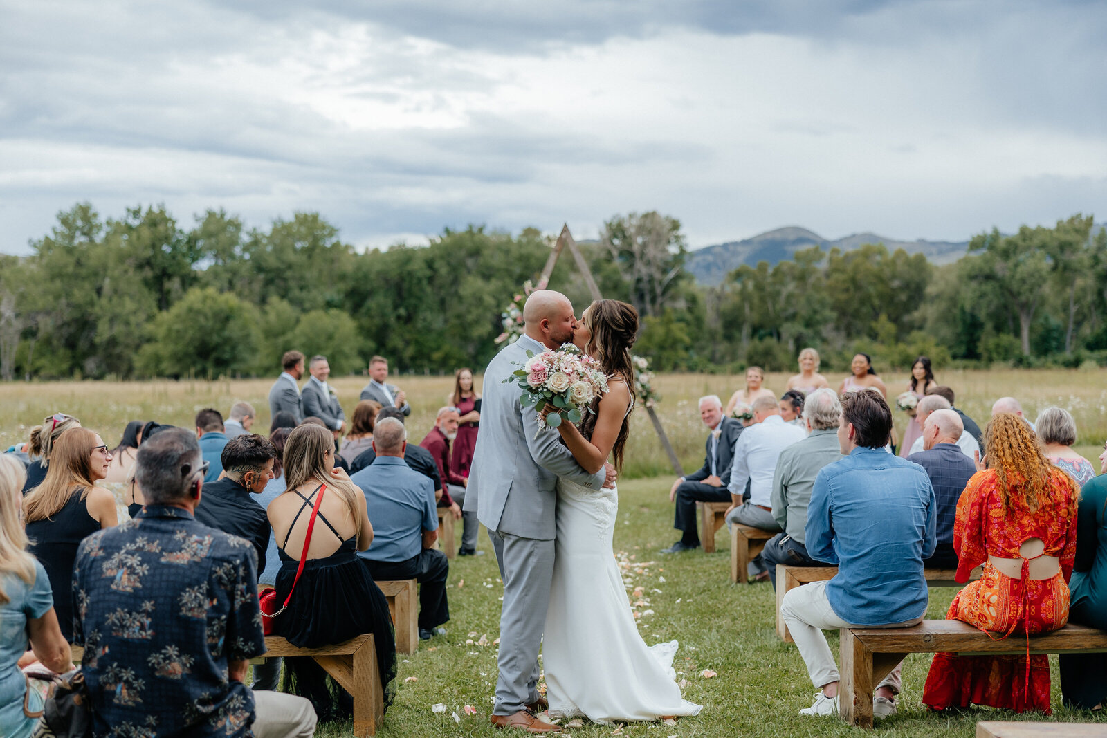 Denver Wedding Photographer captures couple kissing after outdoor wedding ceremony