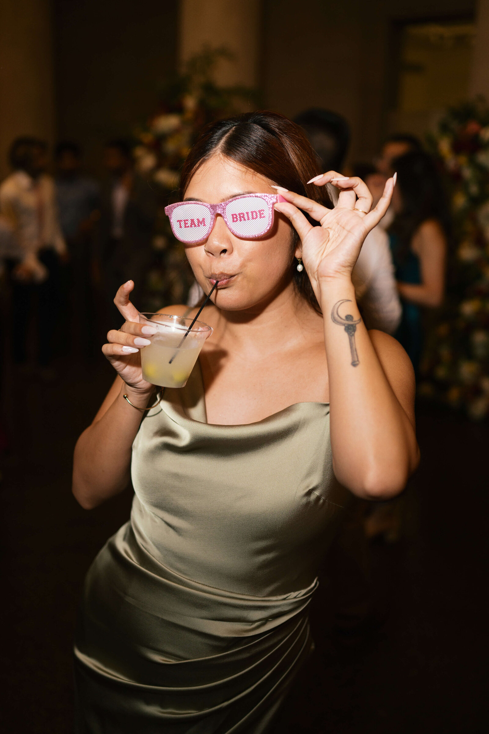 A bridesmaids dances and shows off her fun sunglasses during the wedding reception