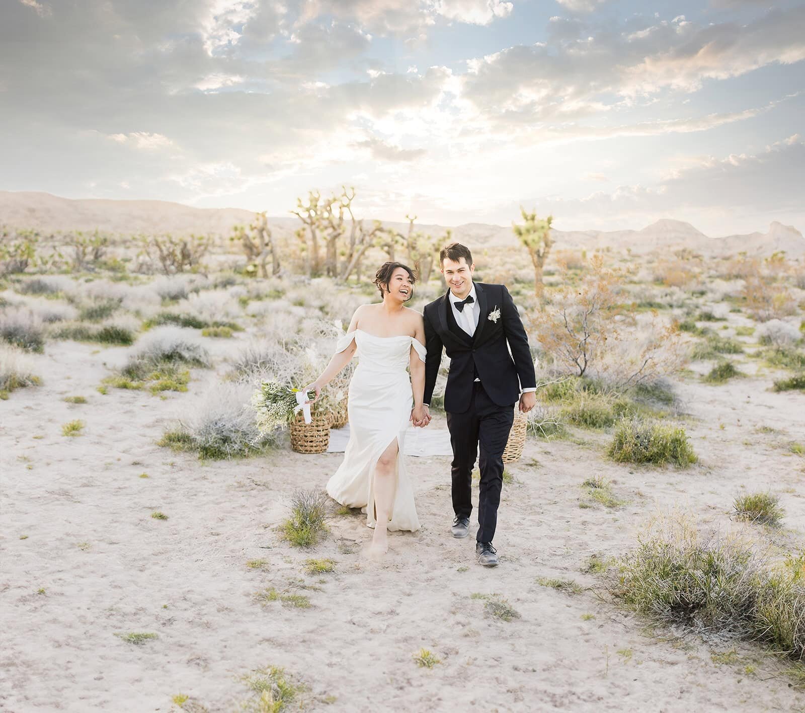 A bride and groom walk among the Joshua Trees while holding hands on their Joshua Tree Elopement. 