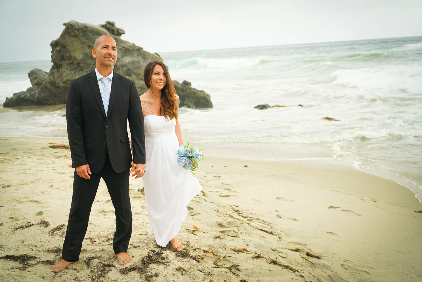 Weddings and Family Portraits in Orange County bride and groom walking together along the beach in Newport Beach, CA