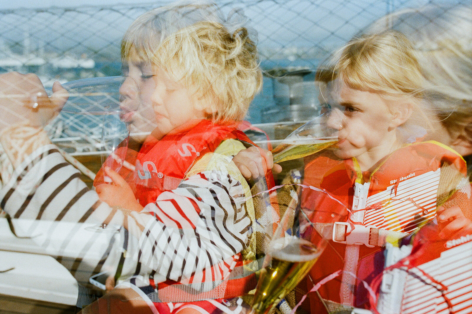 double exposure of two kids in life jackets drinking sparkling apple juice