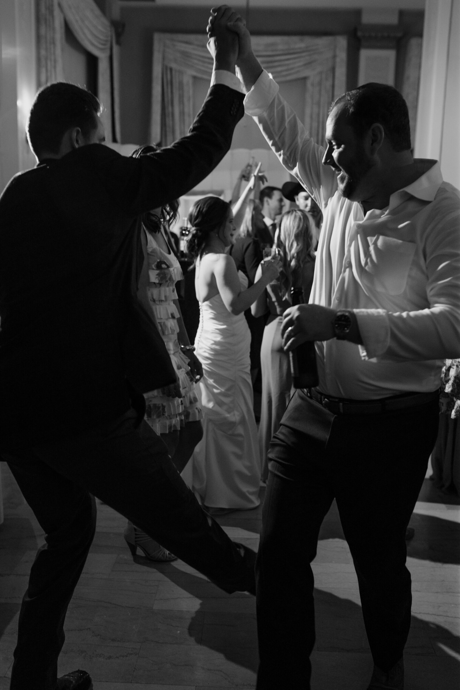 The bride dances with two guests during a hotel wedding reception