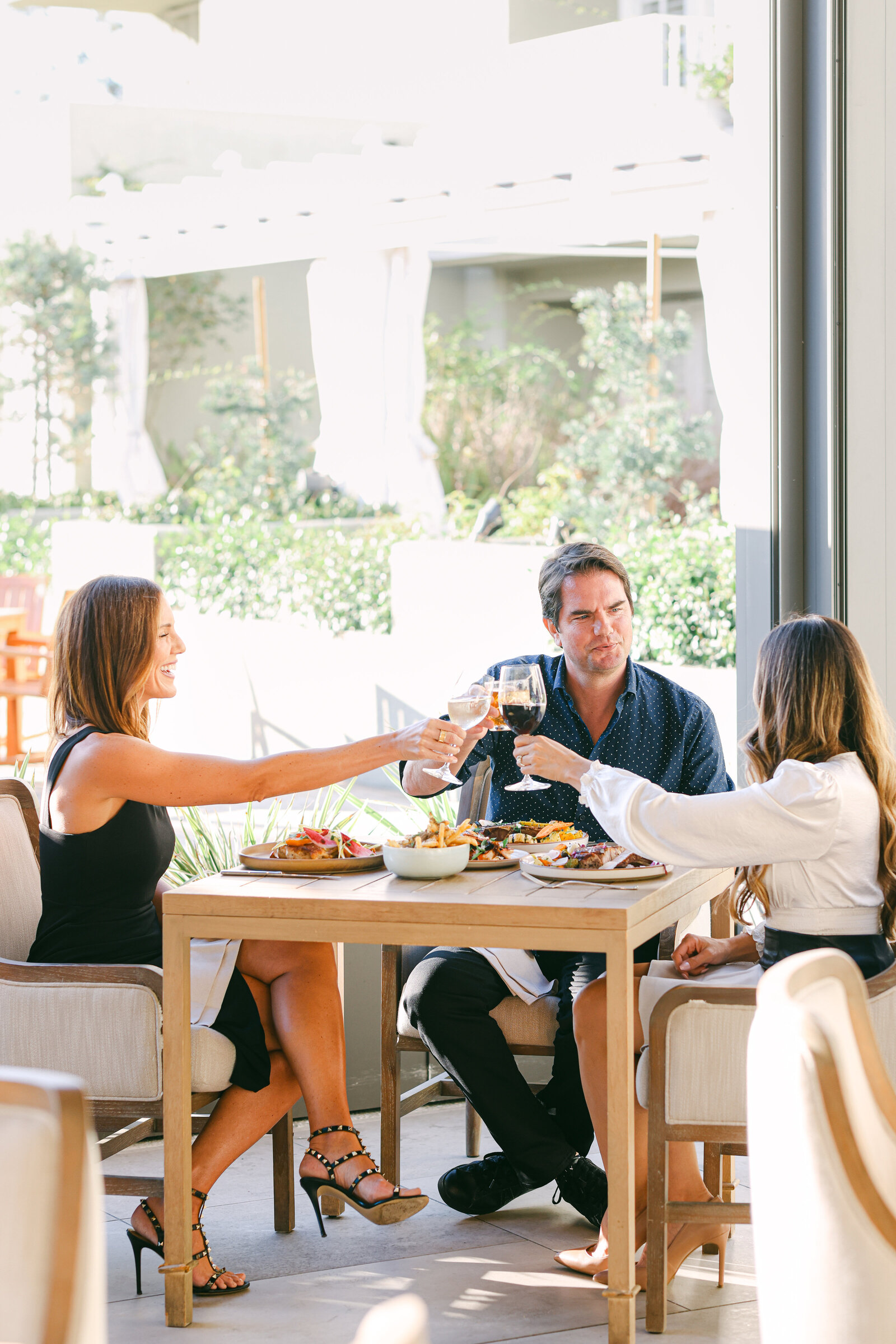 Chelsea Loren for L'Auberge Del Mar. Group sitting in restaurant eating meal for luxury boutique hotel photographer