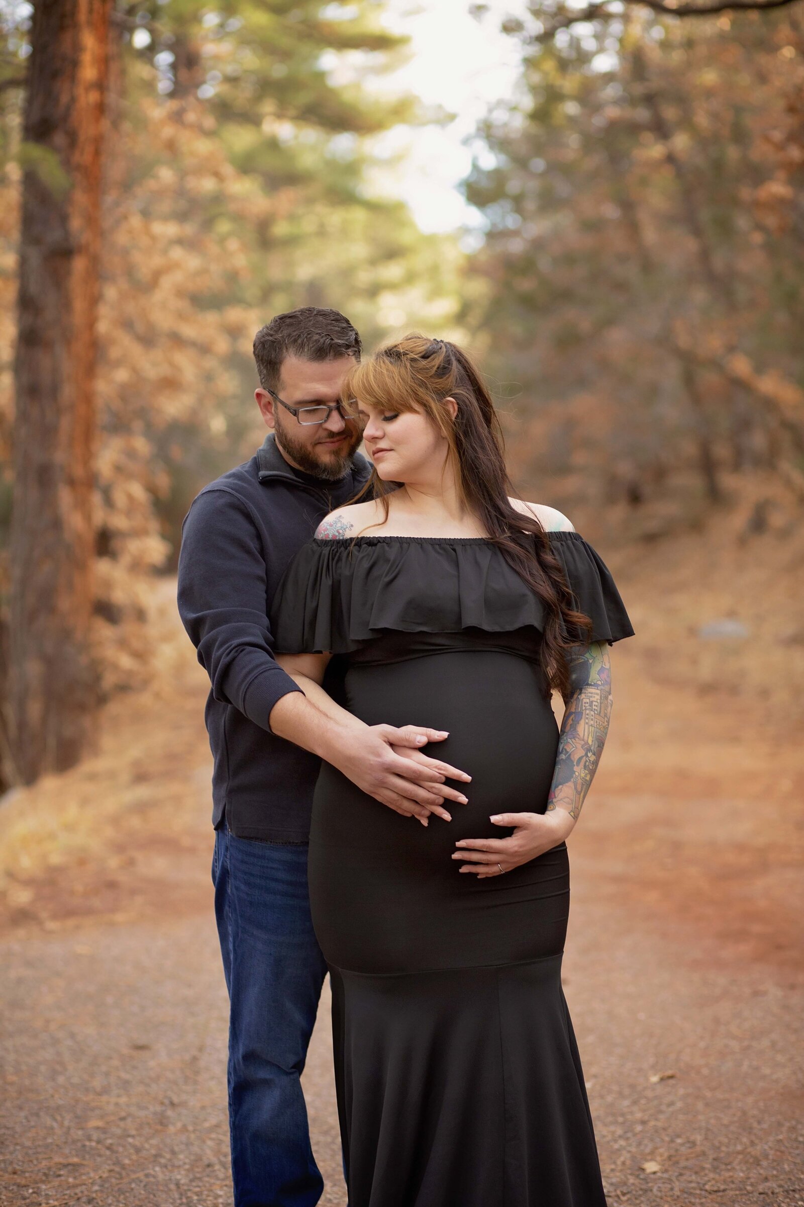 Couple-embracing-maternity-session-black-dress