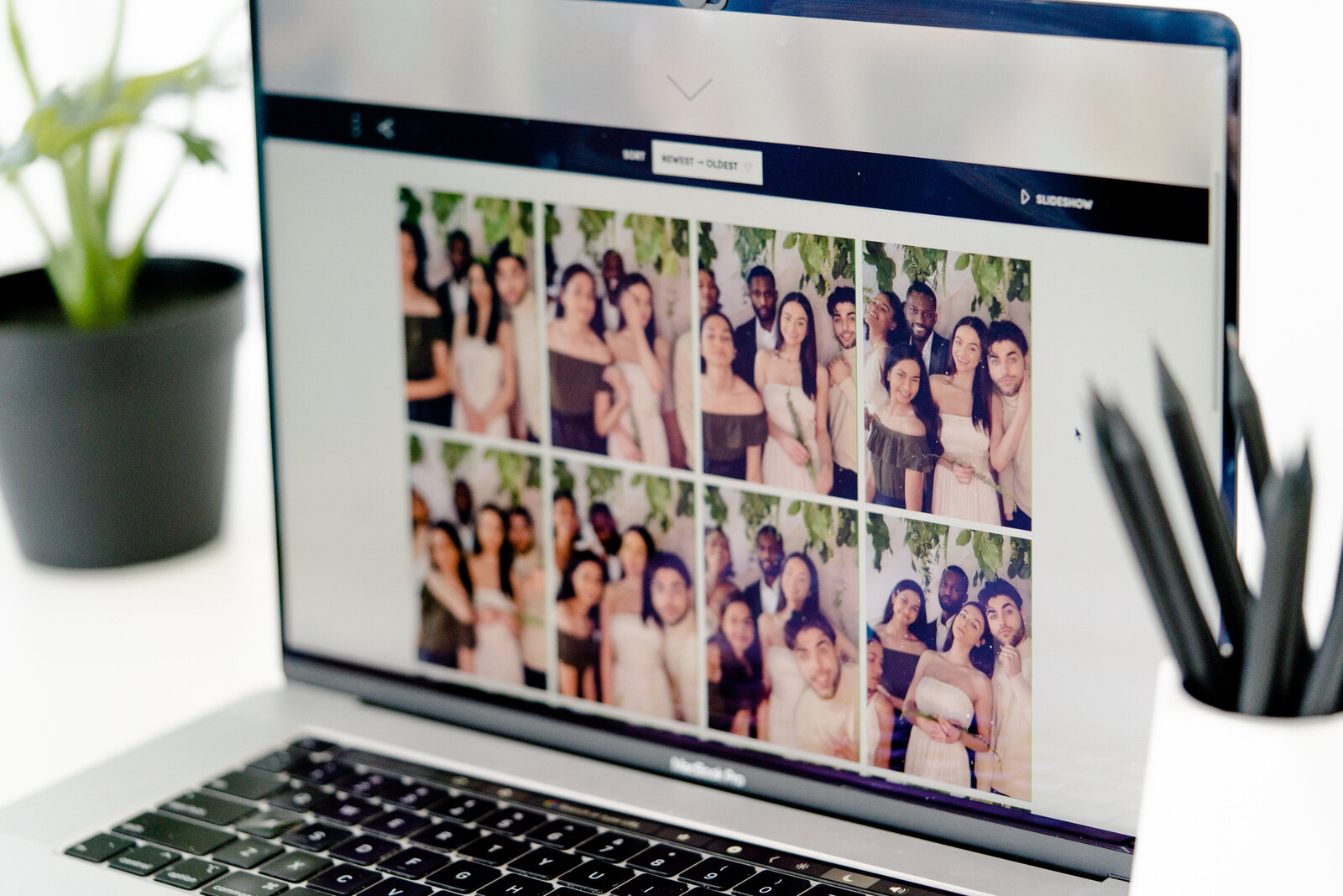 Laptop displaying the client’s digital photo booth gallery with event photos arranged in a clean, modern layout