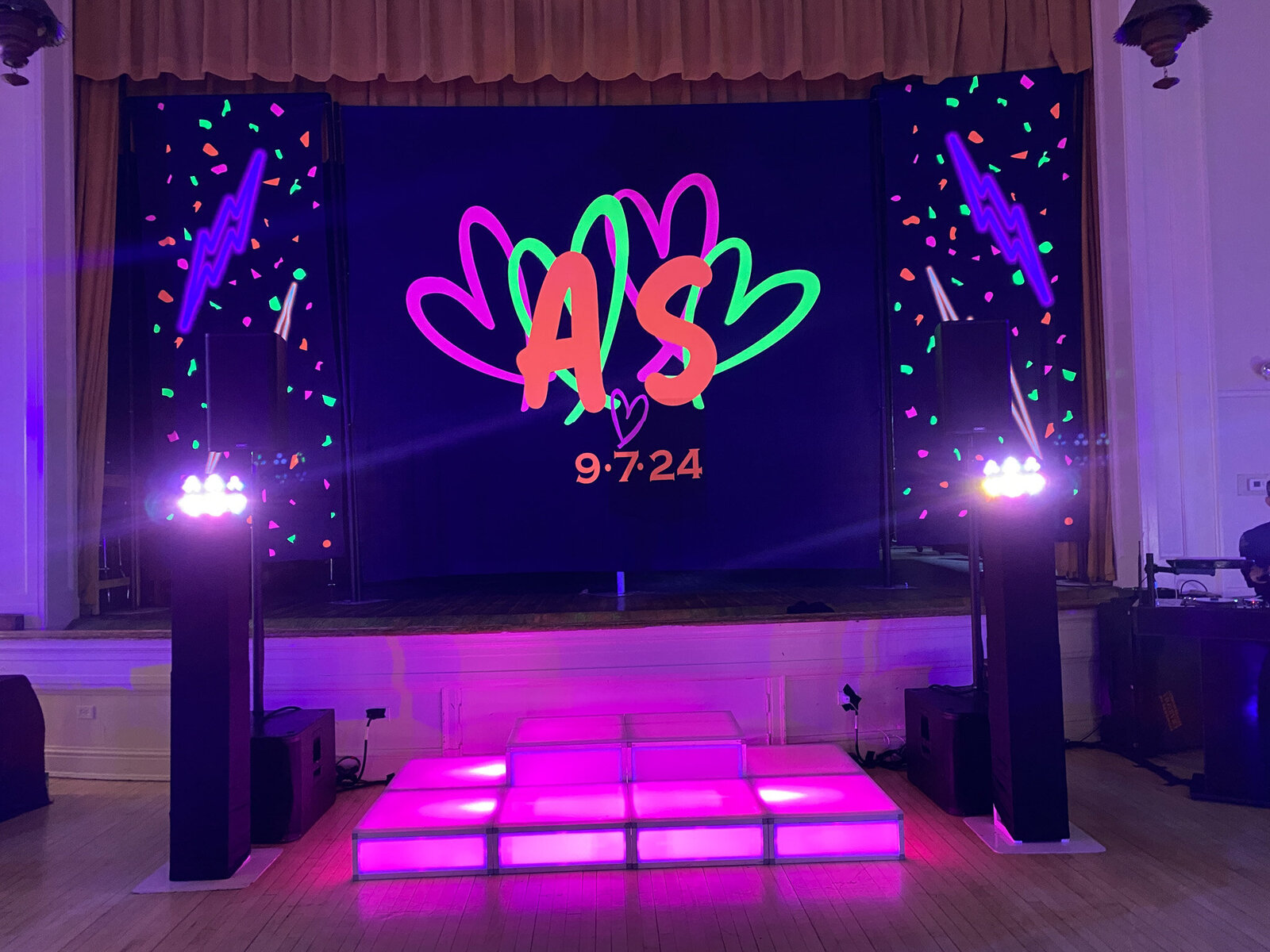 Neon-themed DJ stage with pink lights