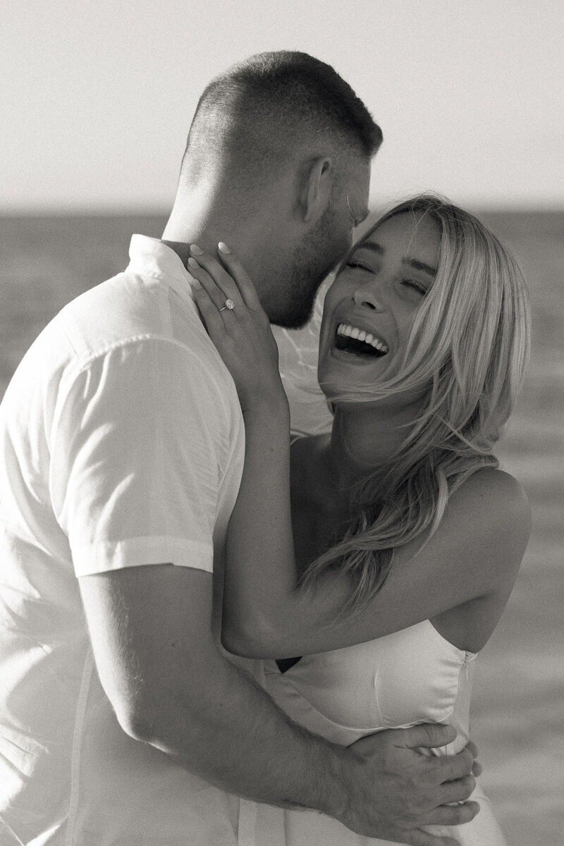 couple smiling and embracing, taken by surprise proposal photographer naples