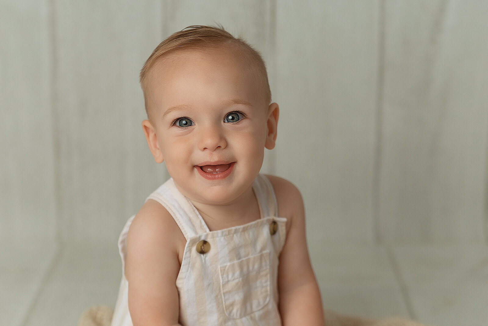 blue eyed little boy smiling at the camera