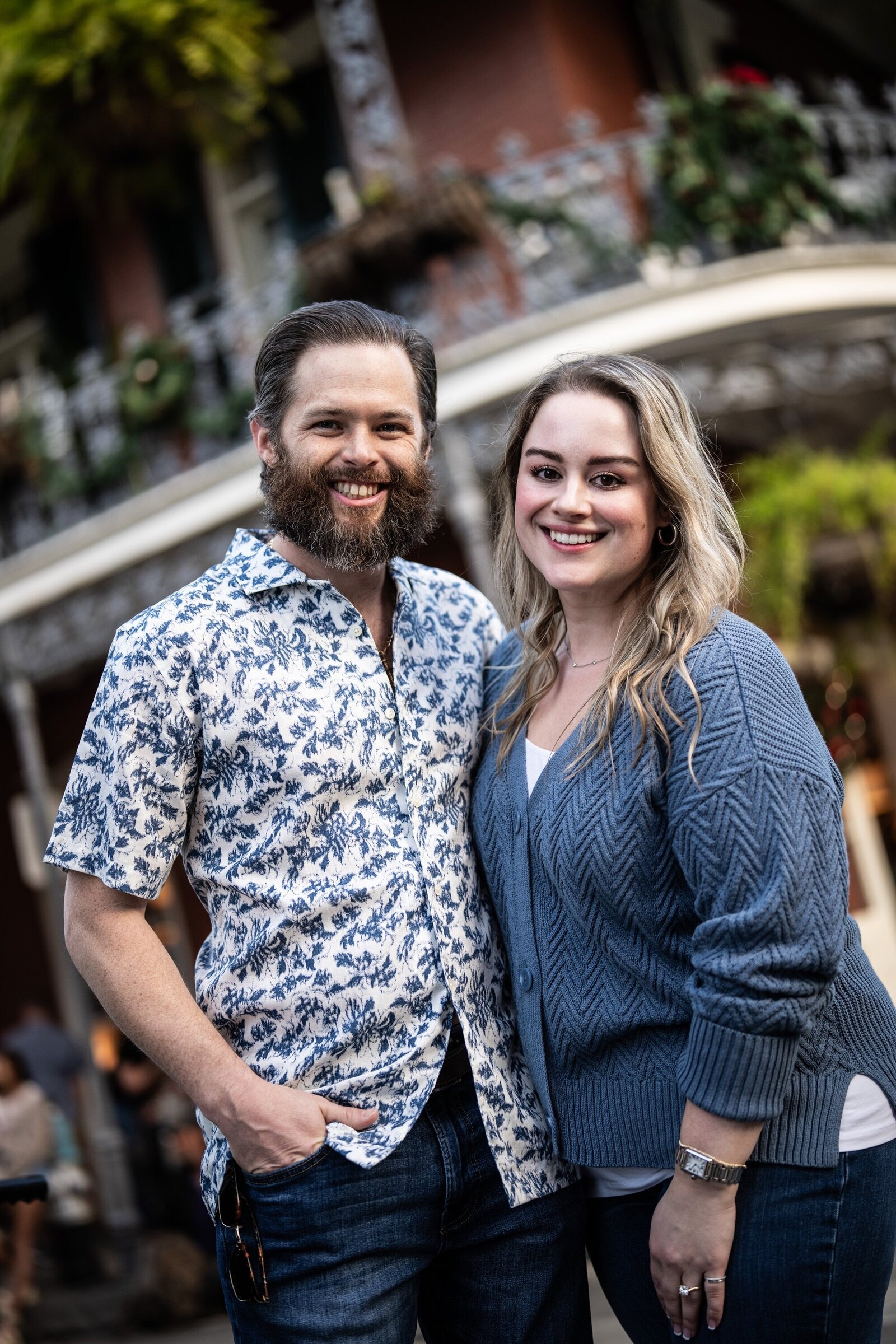Couple in the French Quarter with building with ferns in the background