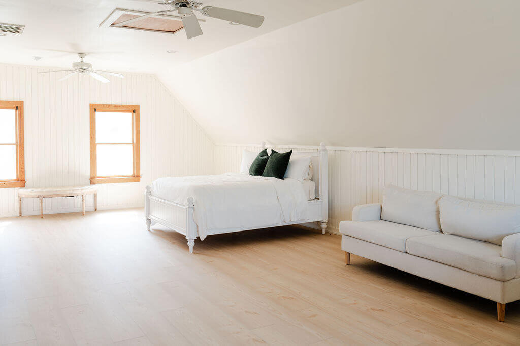 Light-filled room with white bed and couch