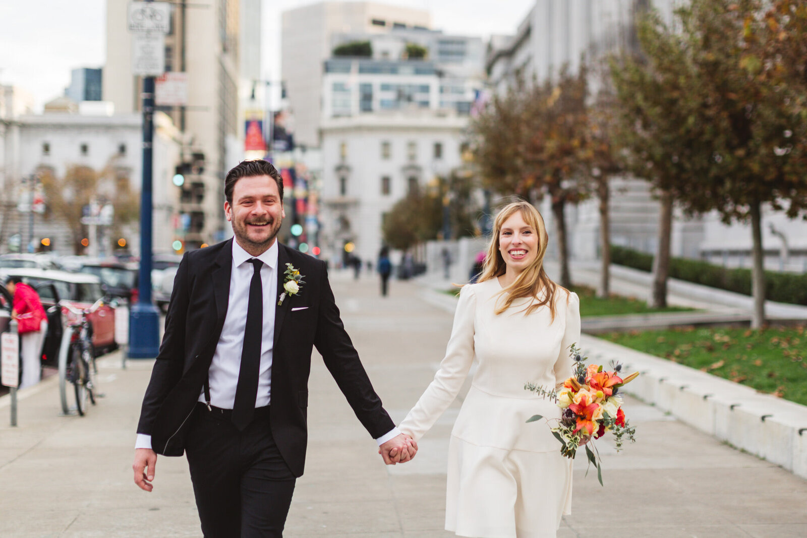 stylish bride and groom walking on the street