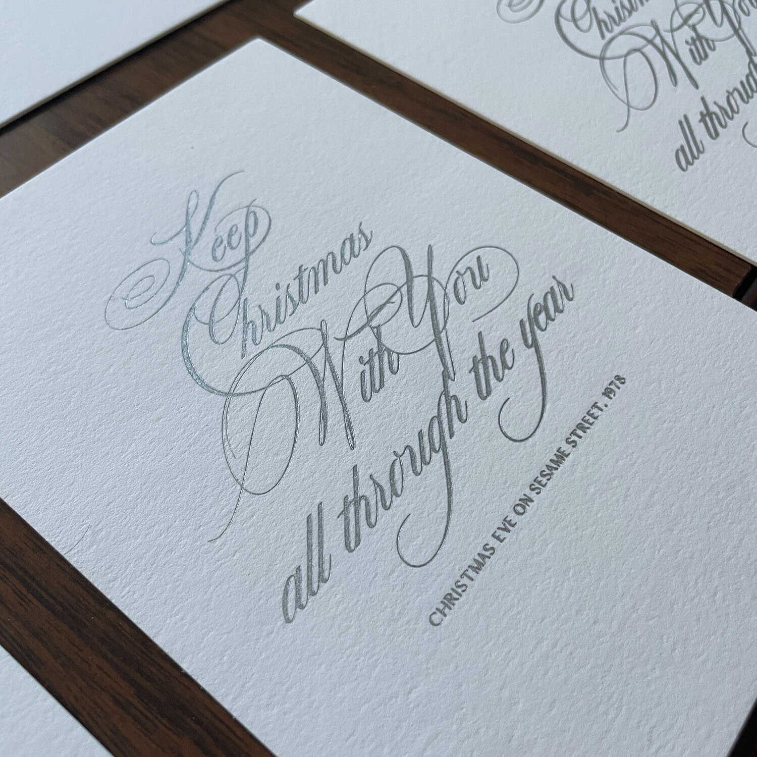 Christmas card with delicate calligraphy in silver ink.