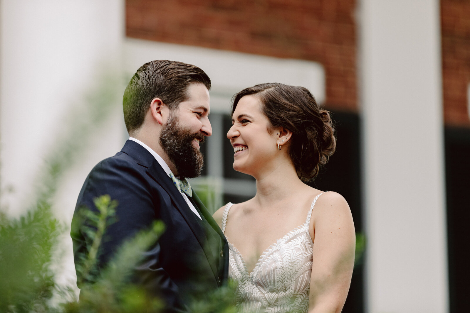 A bride and groom face each other and smile