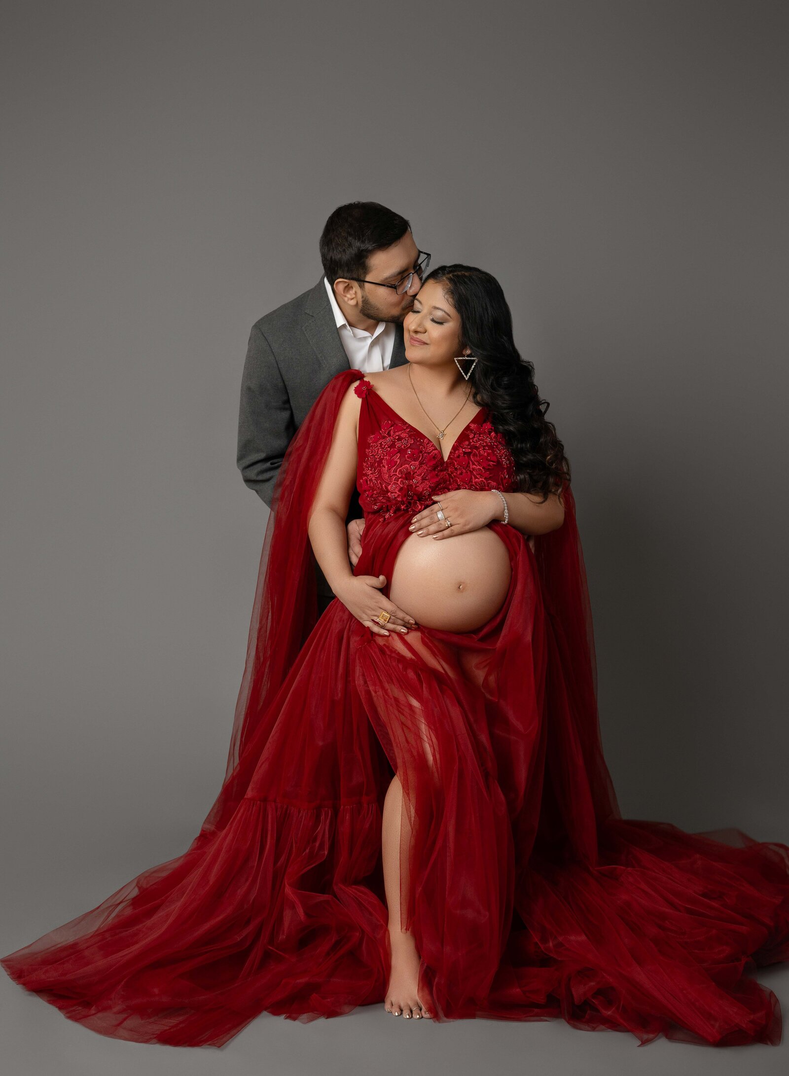 Maternity portrait of couple dressed up and loving on each other. Photo taken at Atlanta Photo Studio.