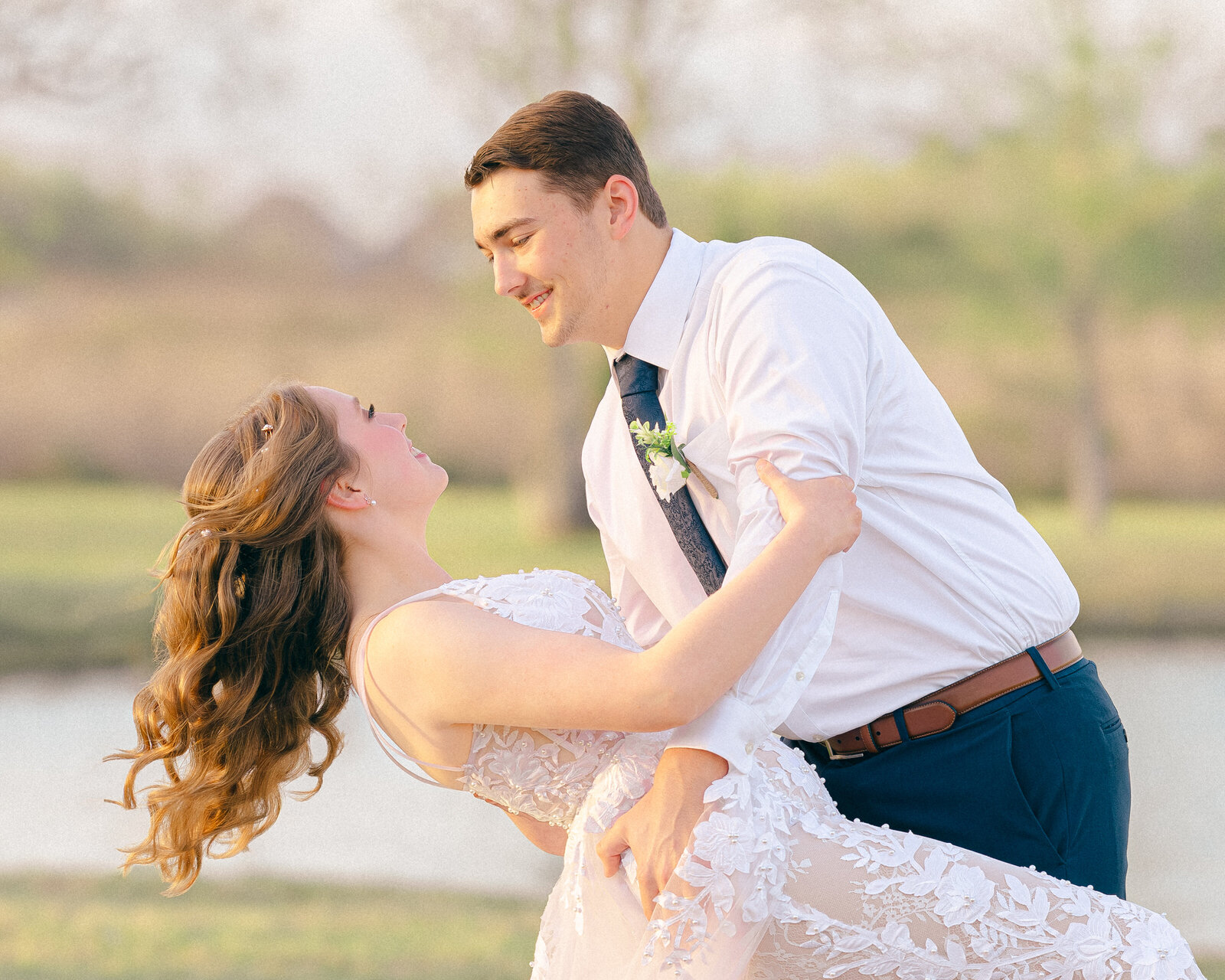 A groom dips his elegant bride during a private moment by the pond on property near Houston, Texas.