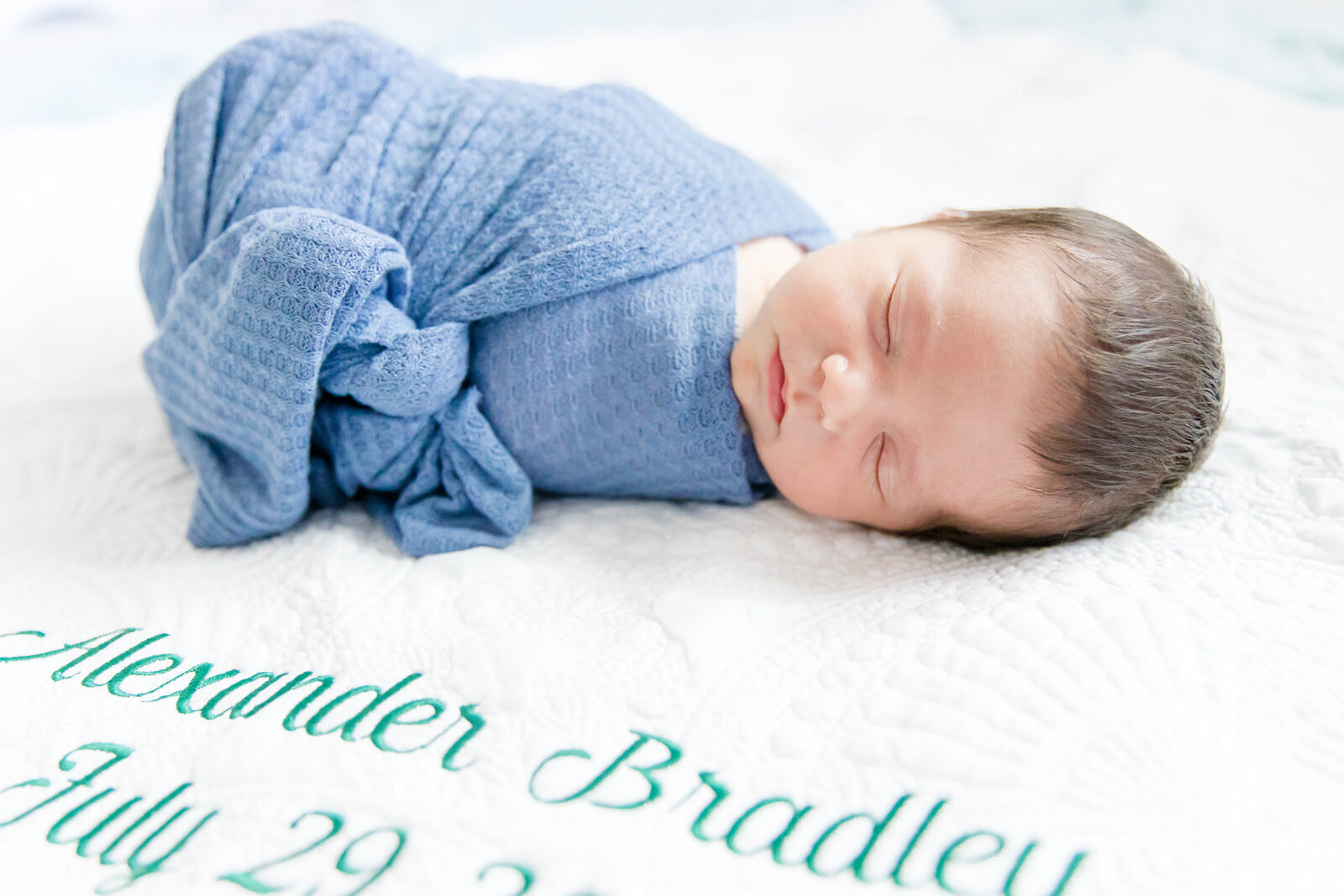Newborn baby boy is swaddled and sleeping during his newborn session in Snellville