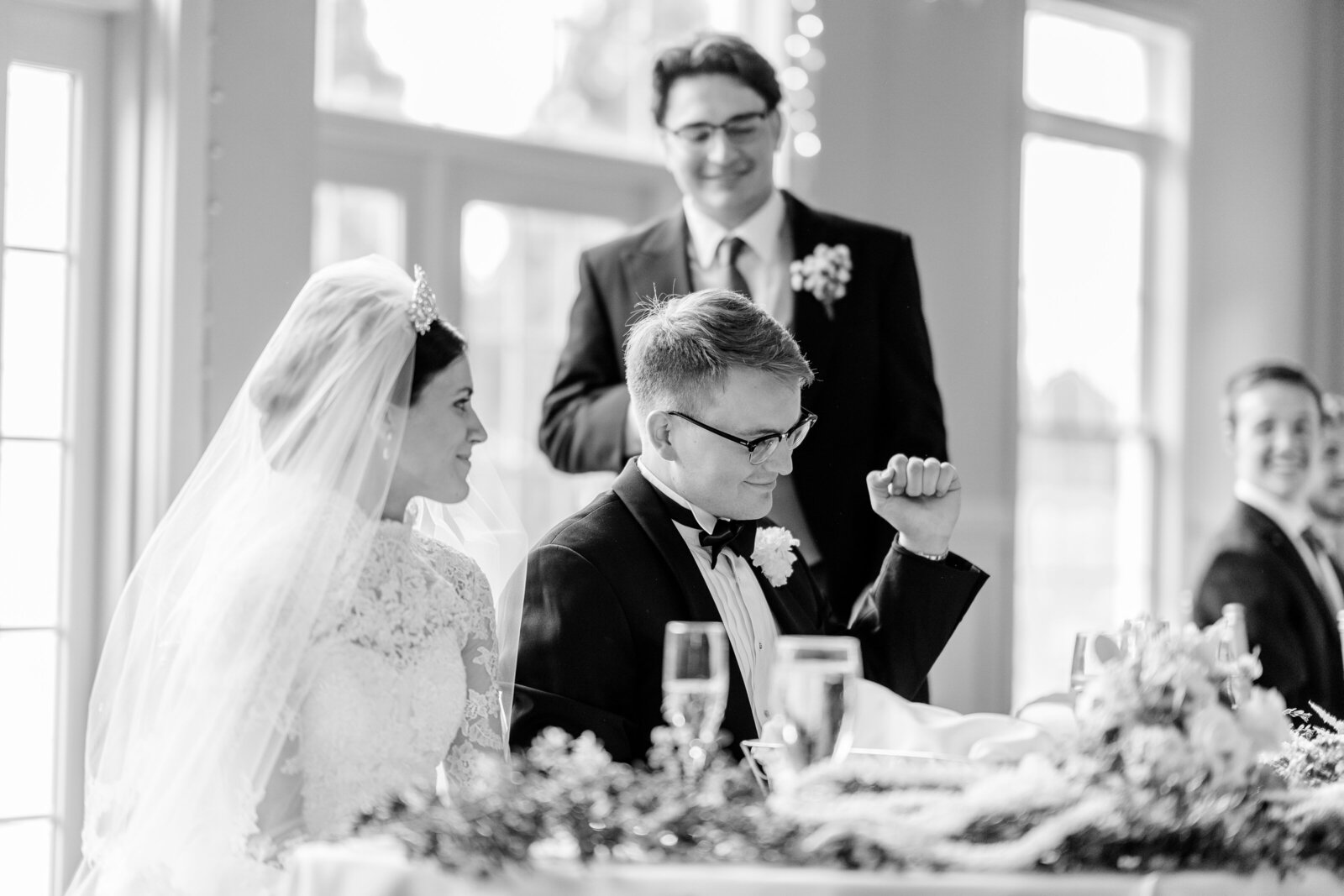 A groom does a fist pump during his best man's toast for his wedding at Westfields Golf Club in Northern Virginia