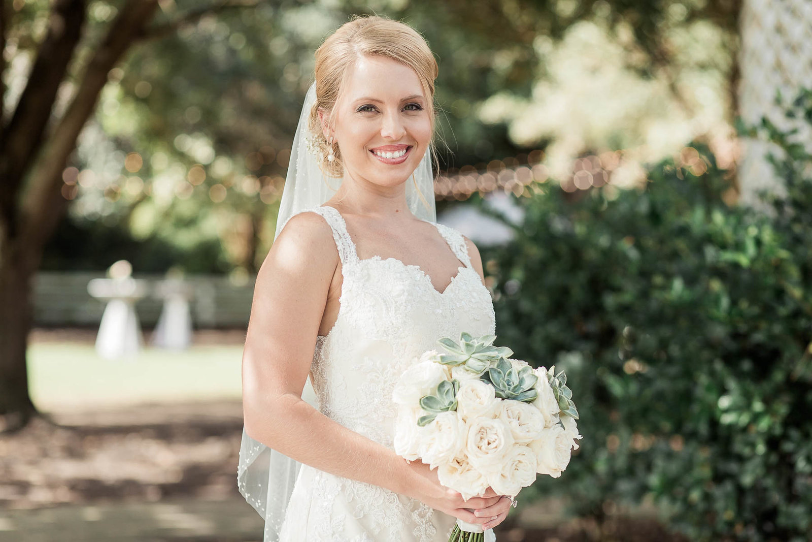 Bride stands underneath trees, Alhambra Hall, Mt Pleasant, South Carolina