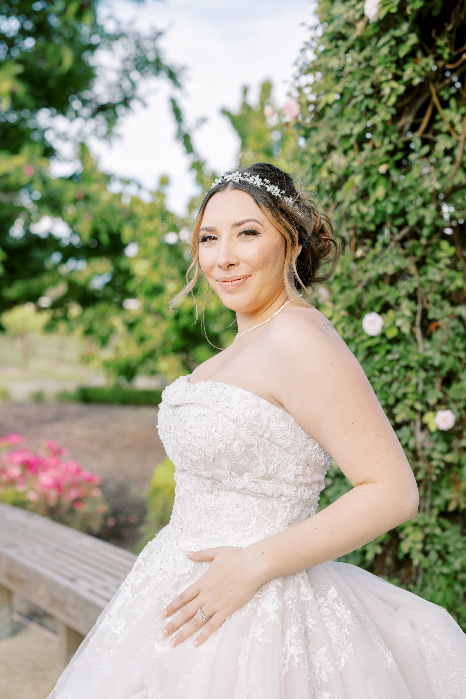 bridal portrait with latina bride in a lace ballgown leaning on a fence and gently smiling at Wolfe Heights captured by sacramento wedding photographer