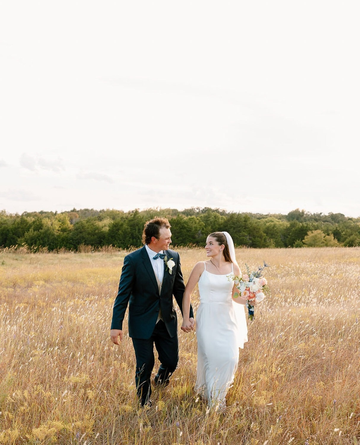 Married couple holding hands in the field