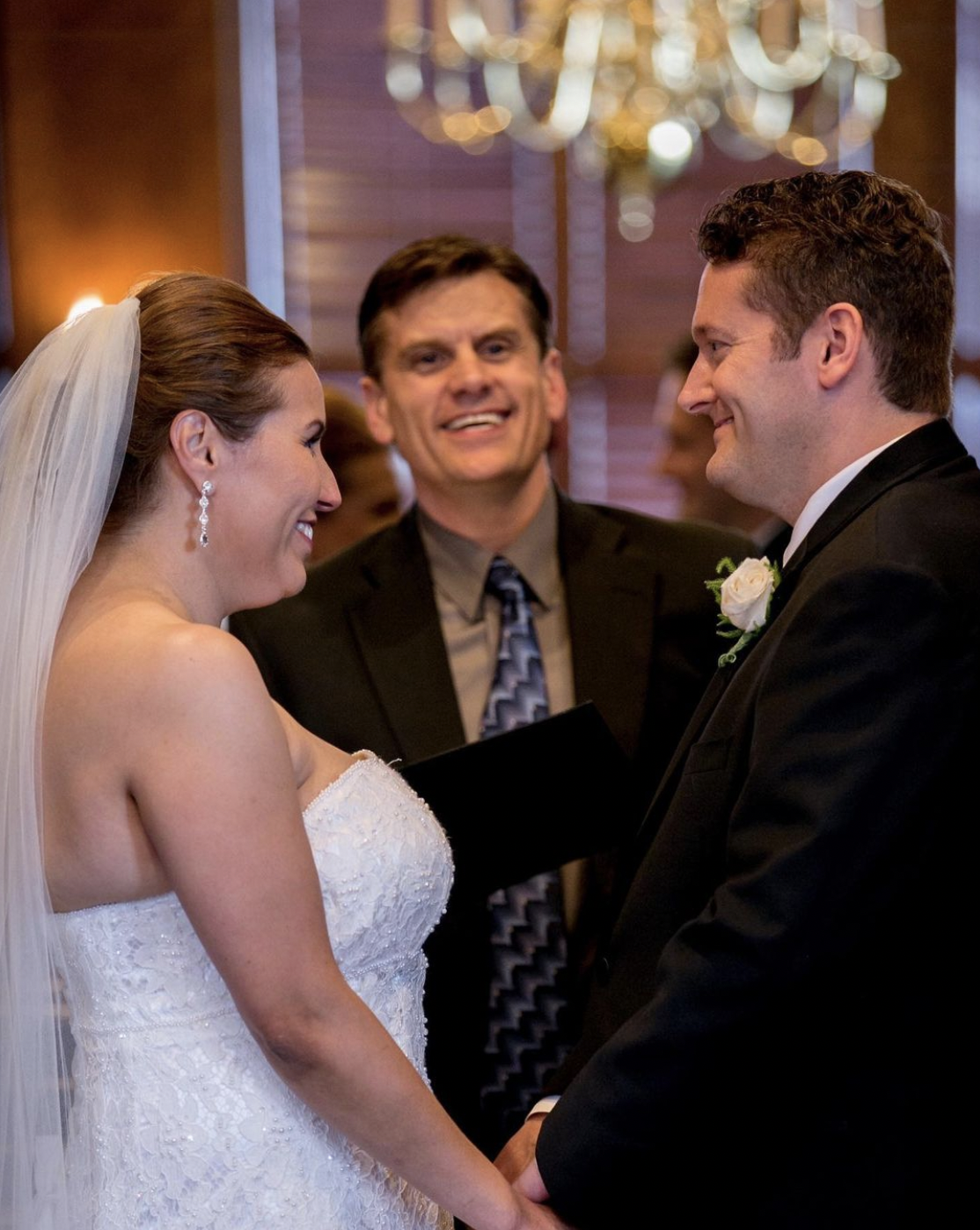 Bride and groom smile at each other during wedding ceremony