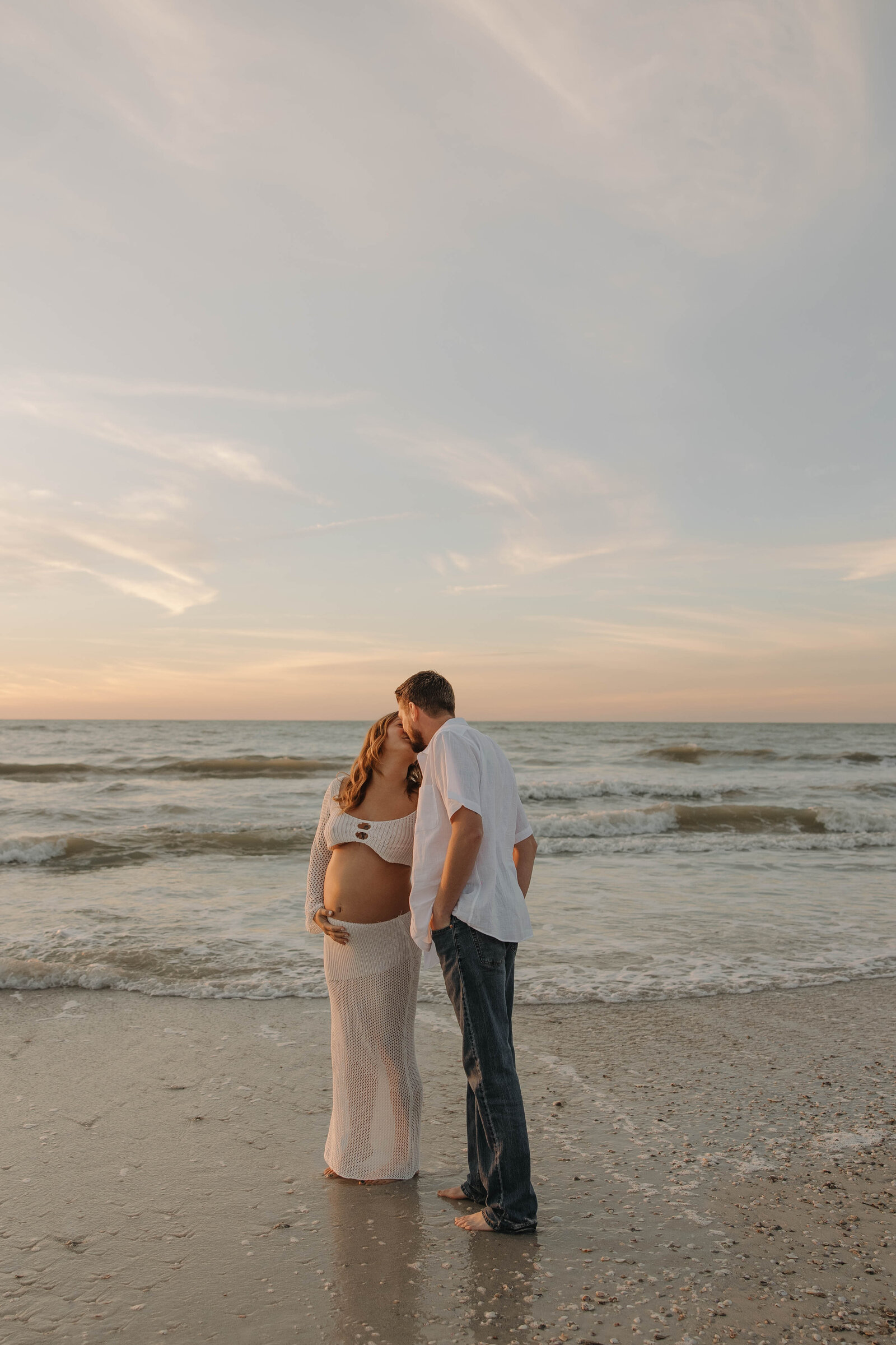 A couple kissing during sunset while at a photography shoot on the beach in Florida.