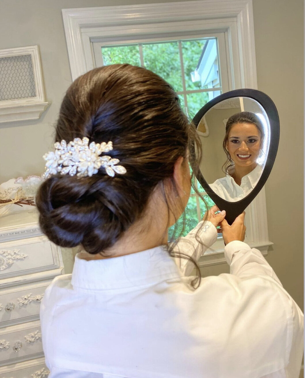 bride with hair done looking in mirror