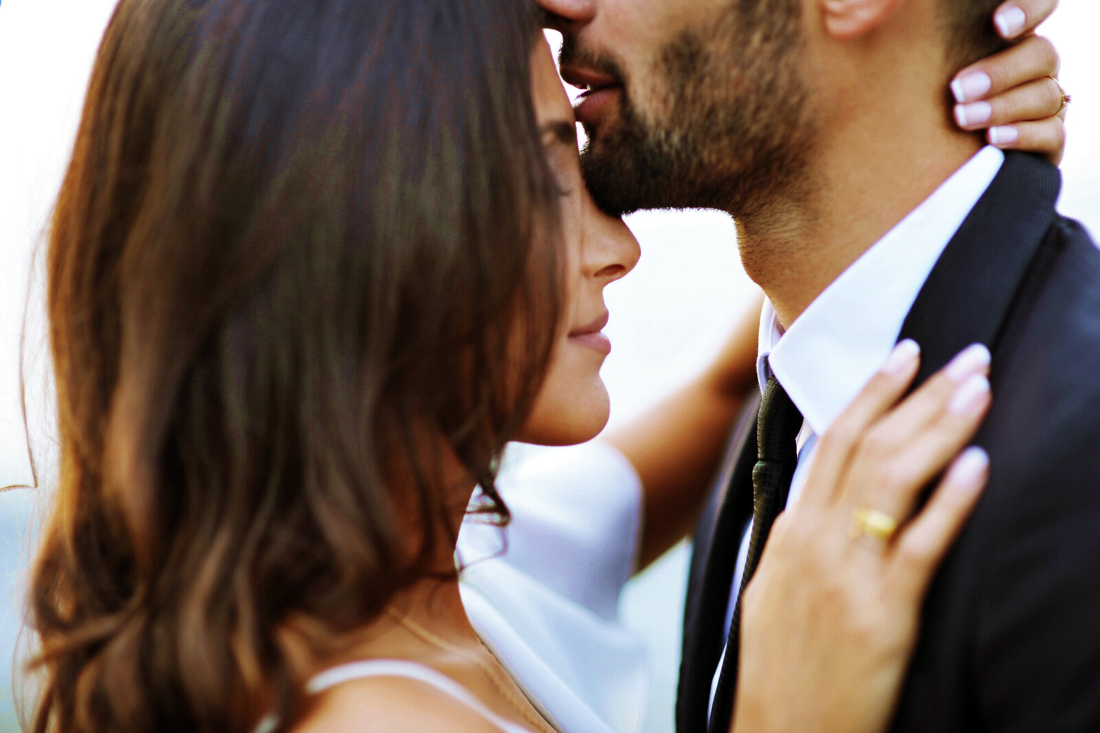 Groom kissing her bride's forehead