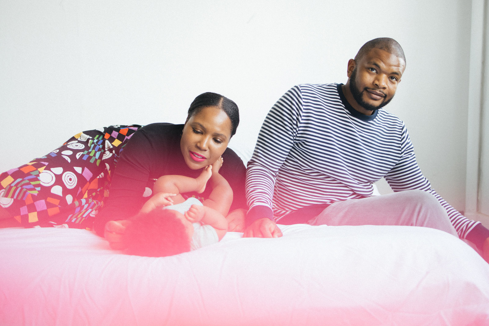 Black family of three on white bed