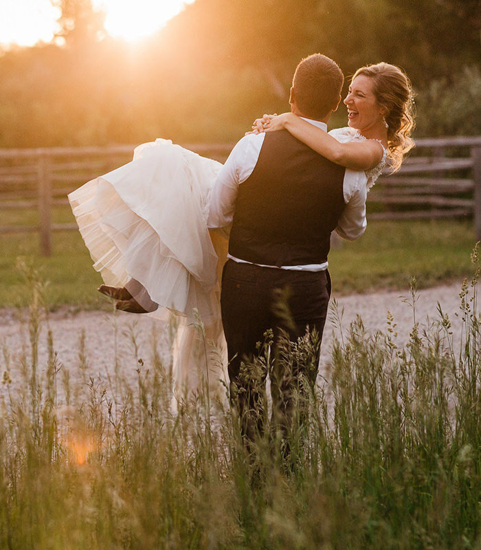 A groom carries his bride at sunset at Moose Creek Ranch photographed by Washington elopement photographer Amy Galbraith