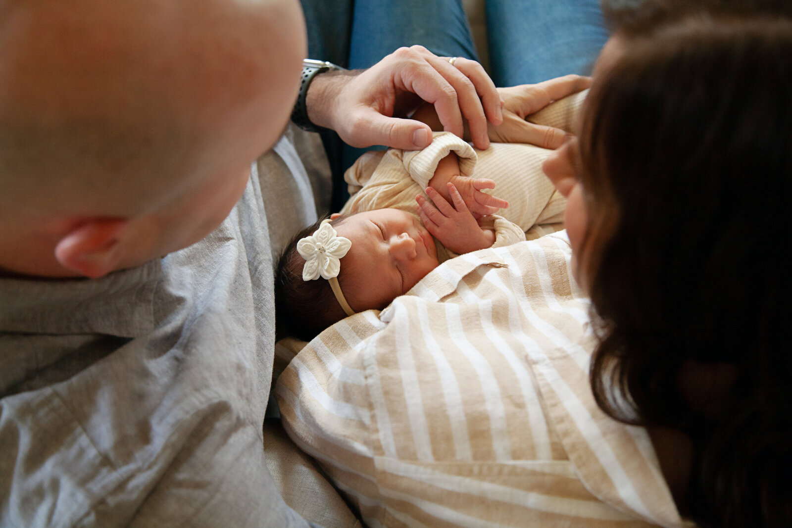 Newborn baby girl in parent arms.