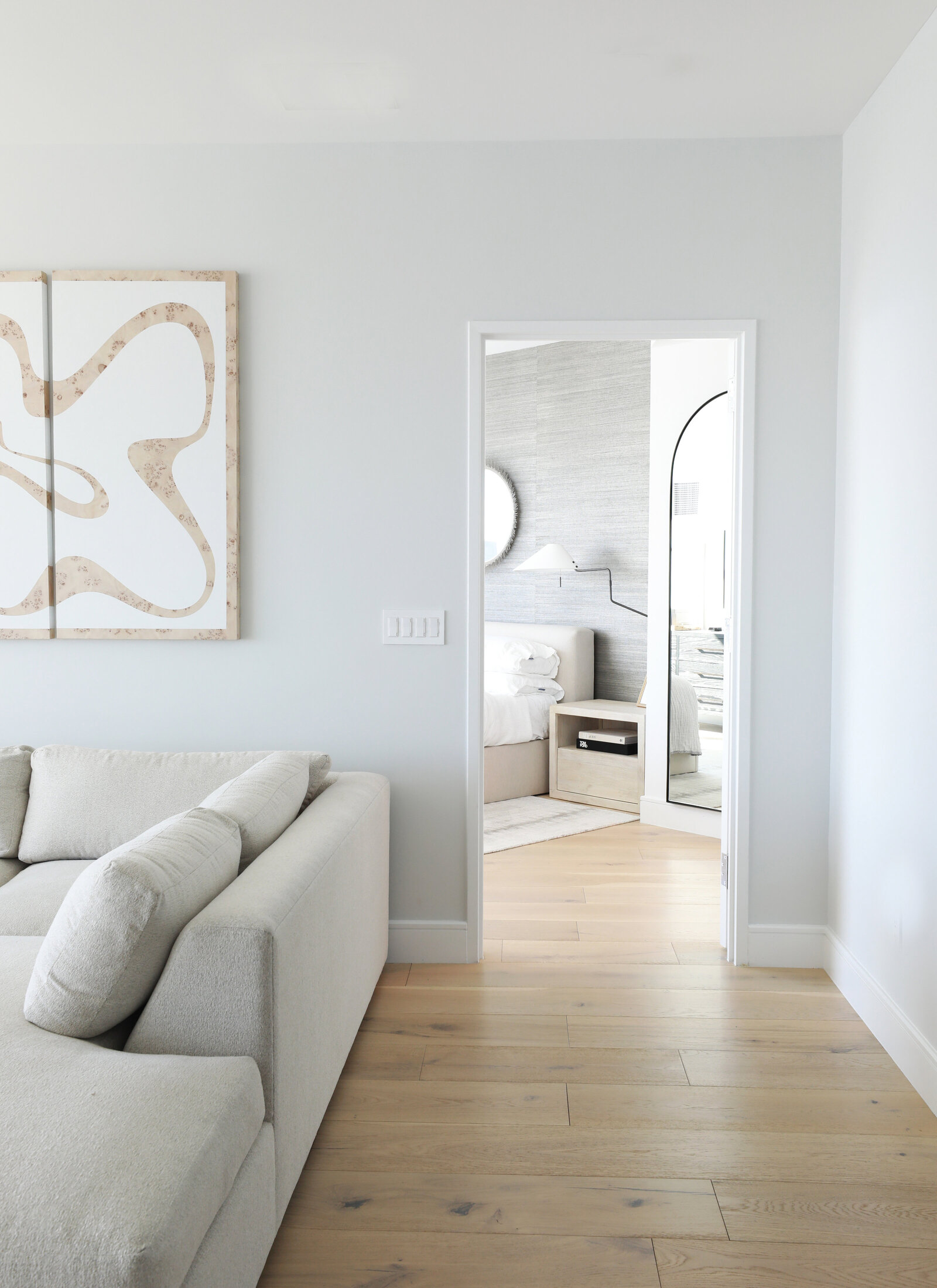 VIEW FROM LUXE MODERN LIVING ROOM INTO POLISHED PRIMARY SUITE