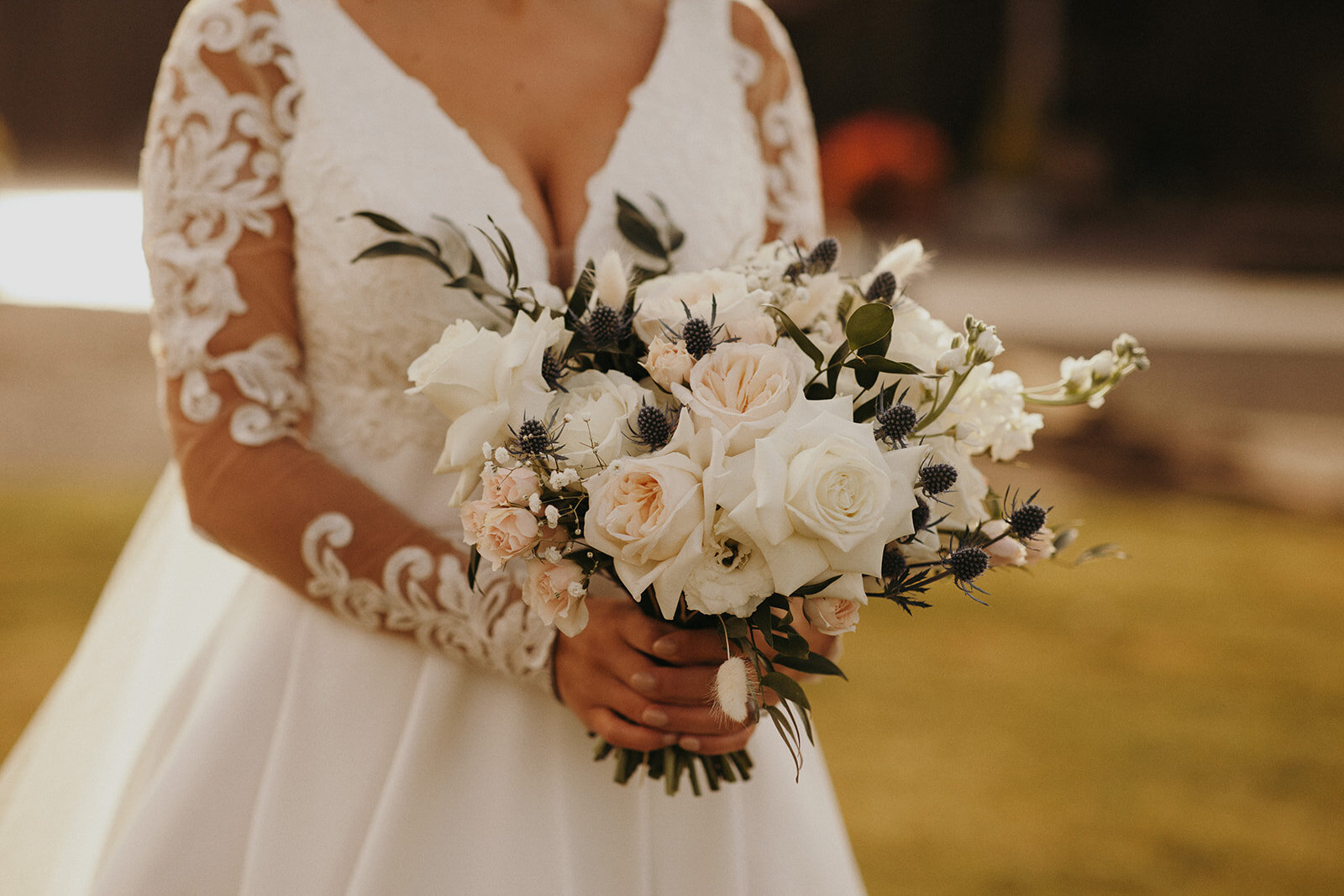 Bouquet with white and blush roses, lisianthus, stock, thistle, ruscus.