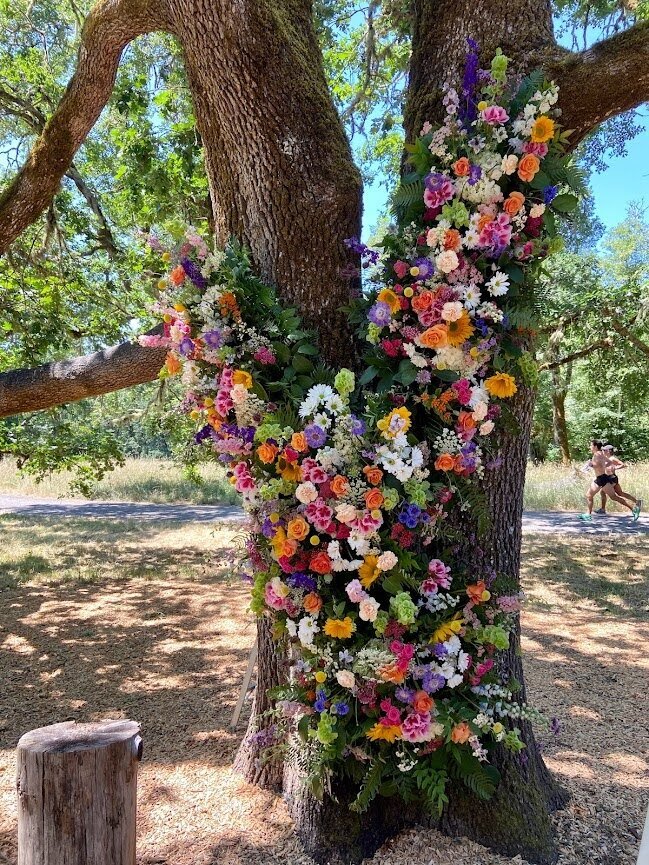 Large floral installation by Flowers and Thyme on a tree representing an example of work in the florist portfolio.