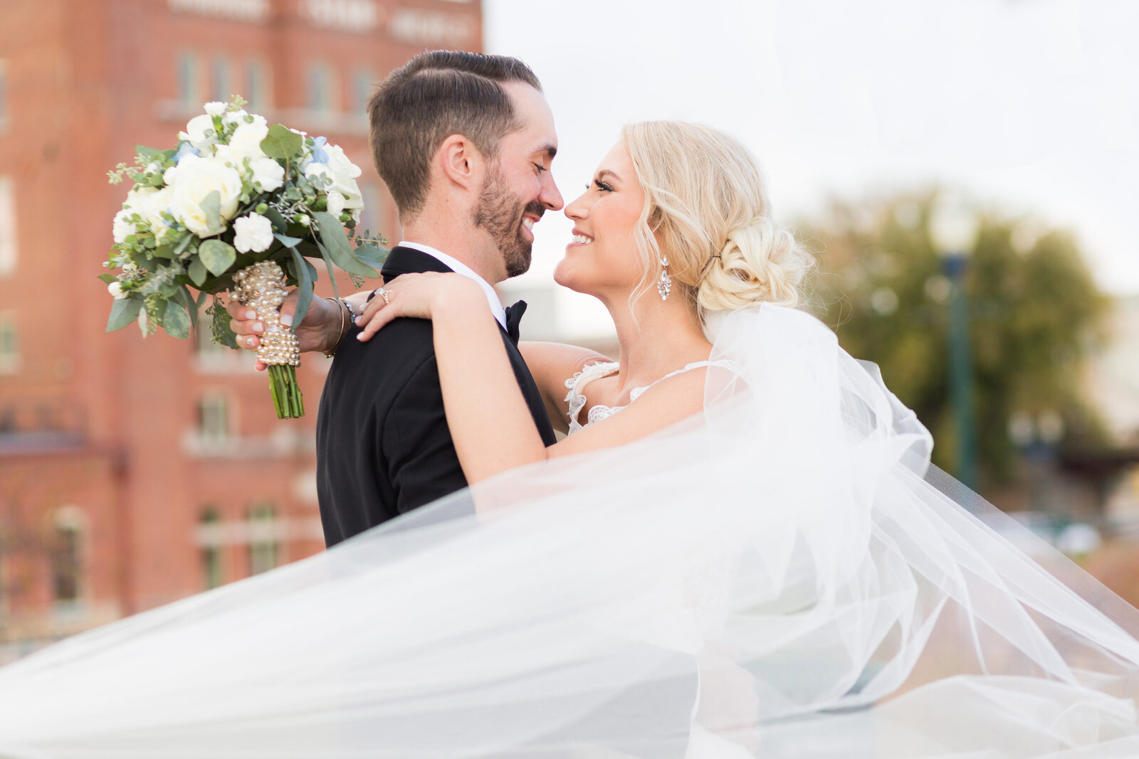 Bride and groom embrace and smile Dubuque Iowa riverfront