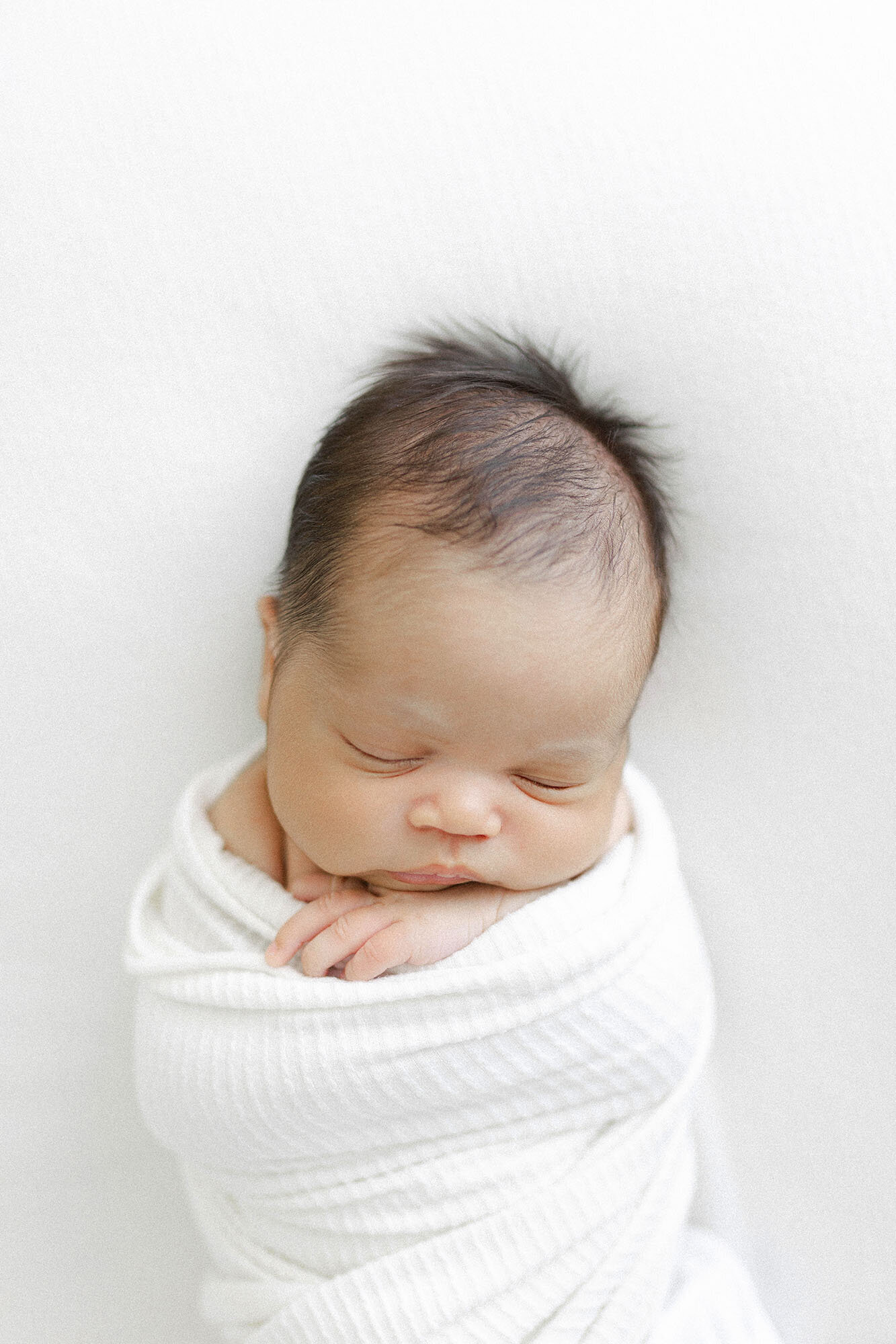 Sleeping newborn wrapped in white | Grand Forks newborn portraits by Chelsea Nichole