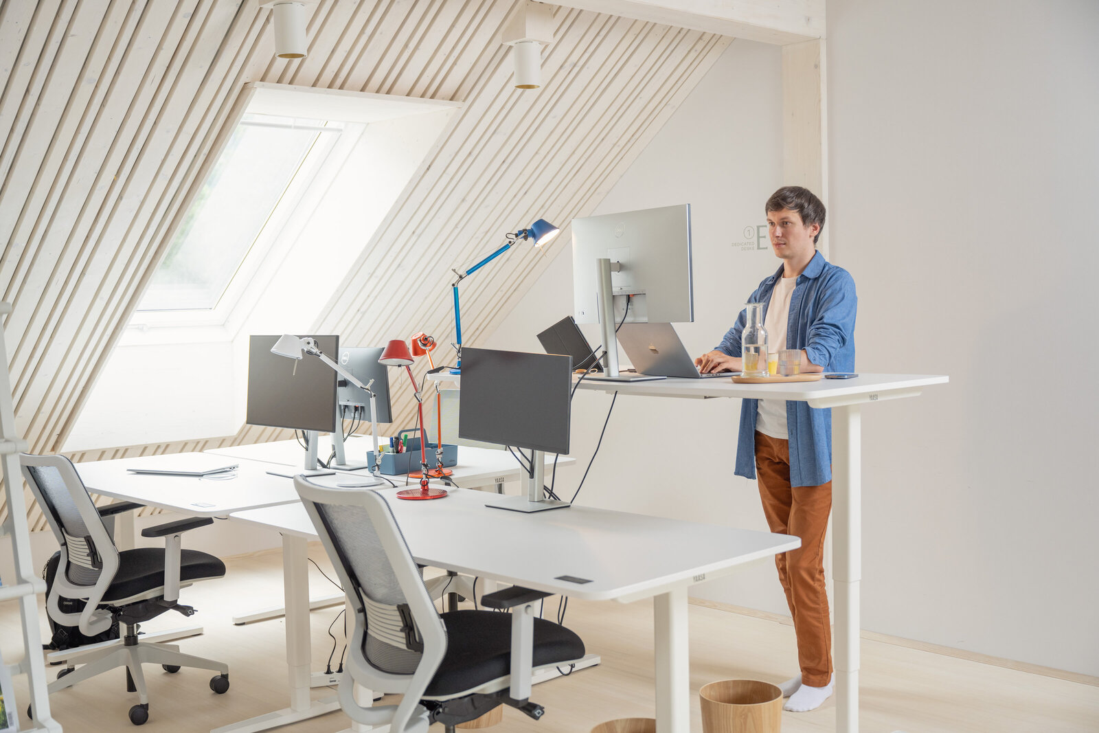 Person working at a dedicated standing desk in The Campus Alps Workbase, enjoying an ergonomic and productive workspace for remote work and company retreats in the inspiring Alps.