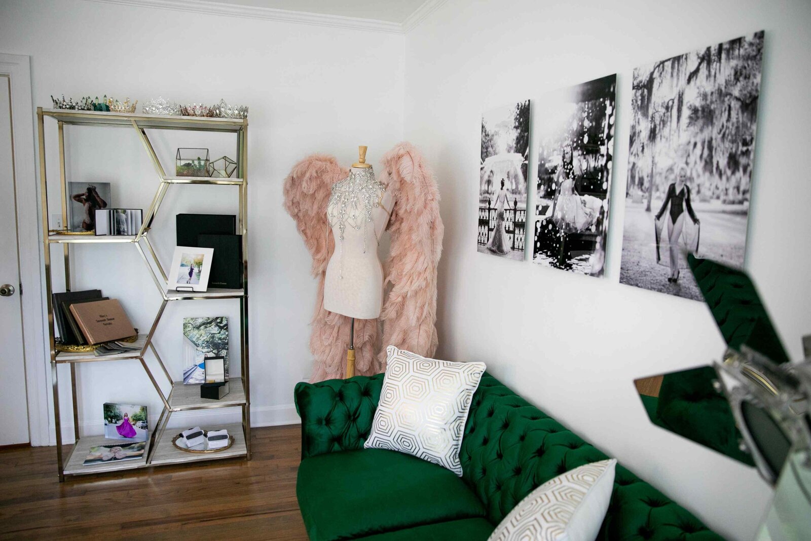 green sofa, wall prints, pink wings and product display case