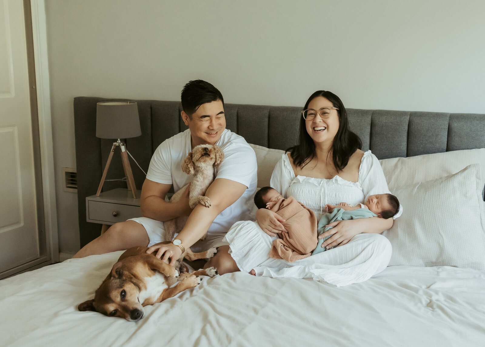 A heartwarming in-home newborn photo session with parents and their twins and two dogs.