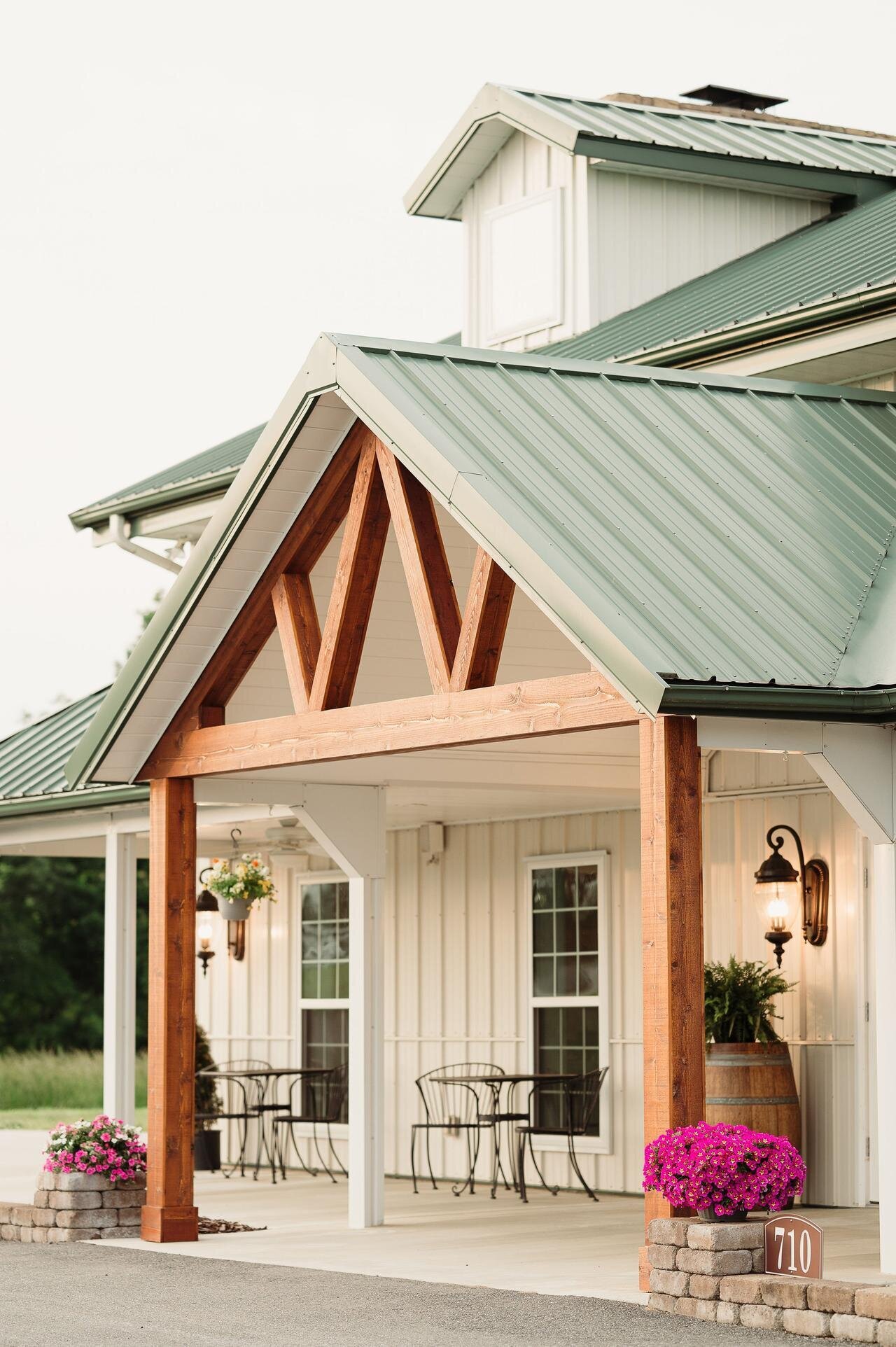 Entrance to Willow and Stone Events in Mocksville, NC, featuring rustic wooden beams, green metal roof, and inviting Southern charm.