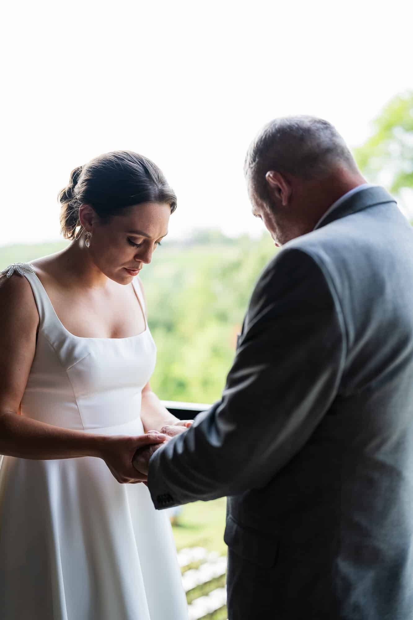 Allie and her father raying before the ceremony at terra incognita vineyard wedding 
