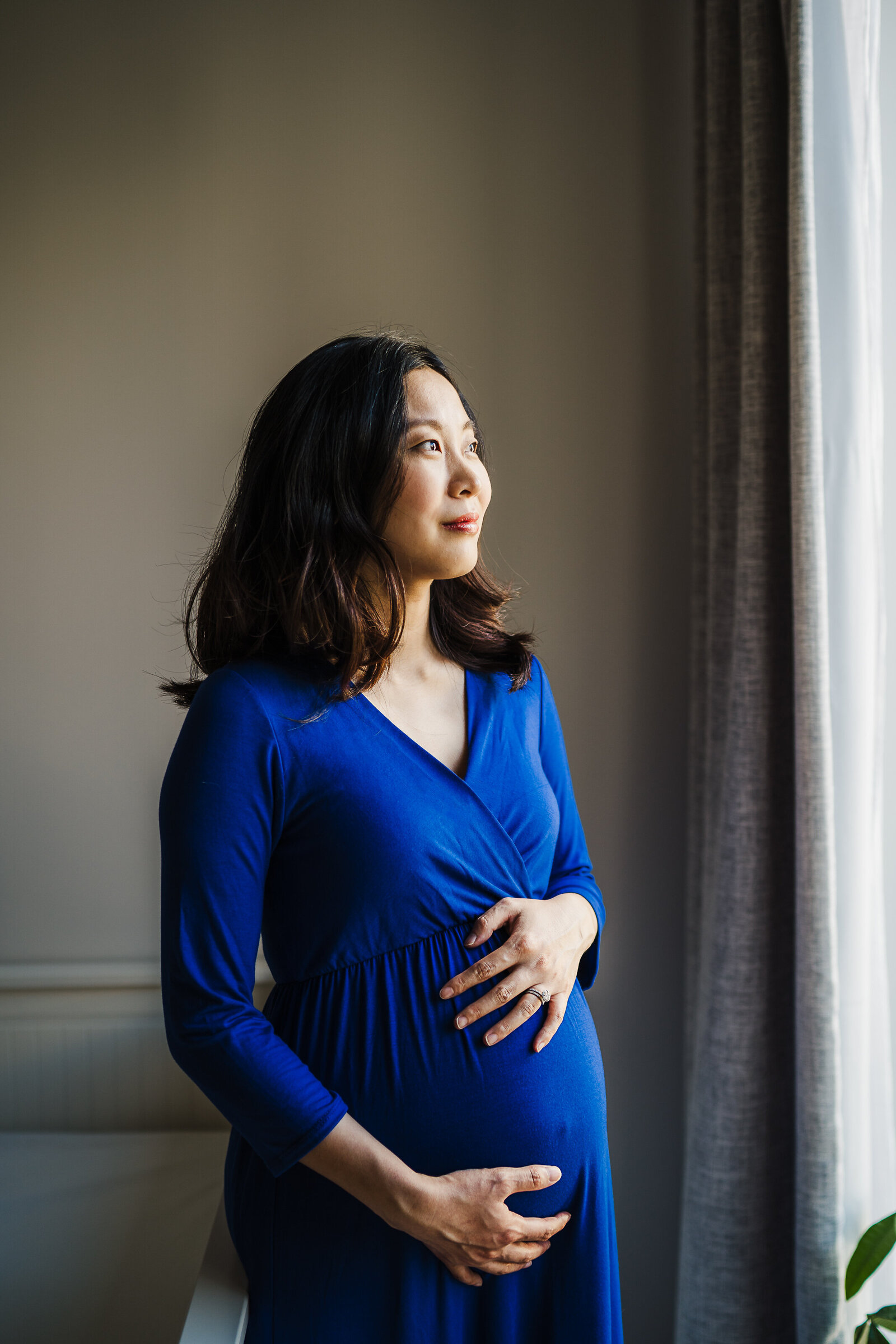 pregnant woman in blue dress for maternity photos in boston