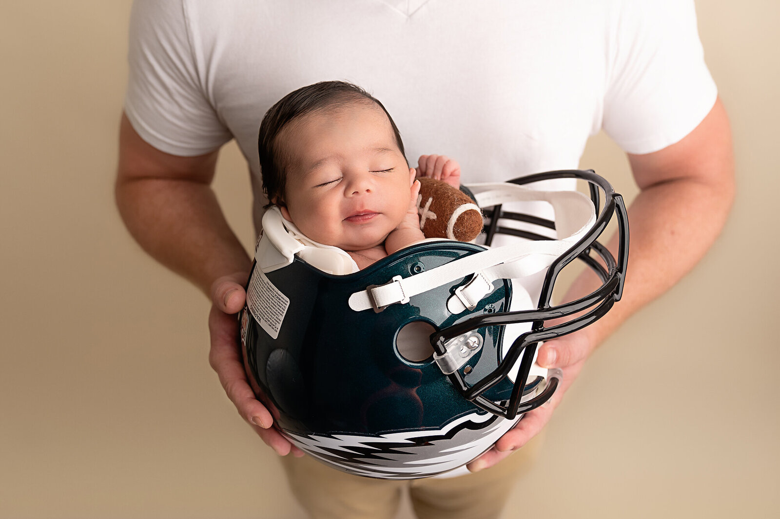 baby in football helmet by Newborn Photography Bucks County PA
