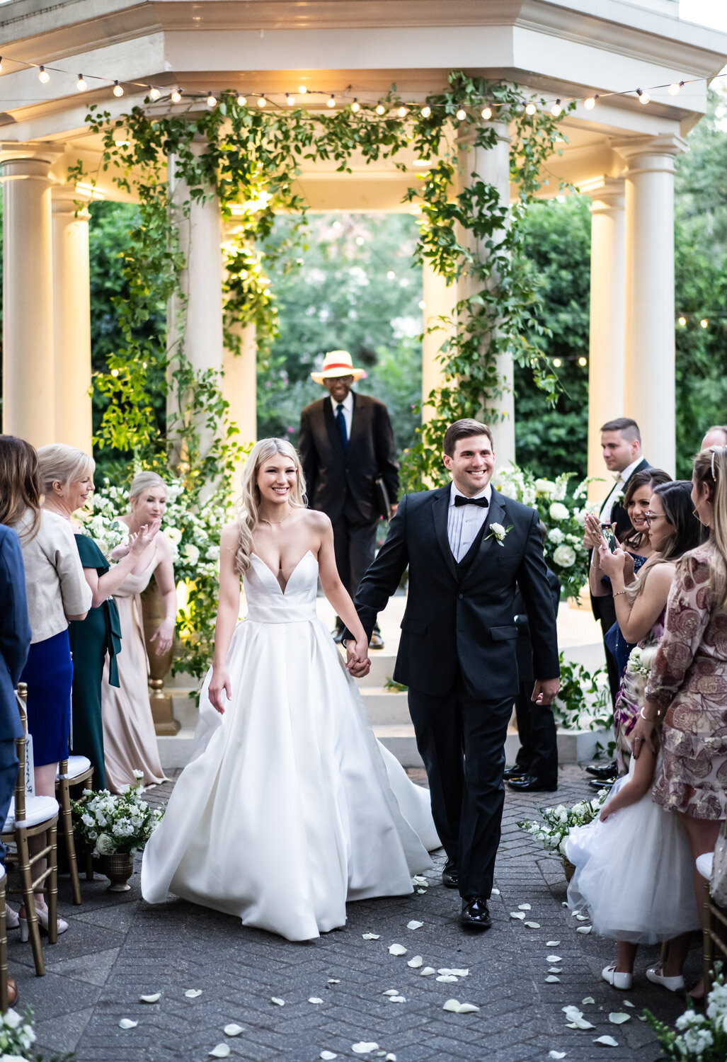 Couple walking out at end of wedding ceremony at Elms Mansion with gazebo in background